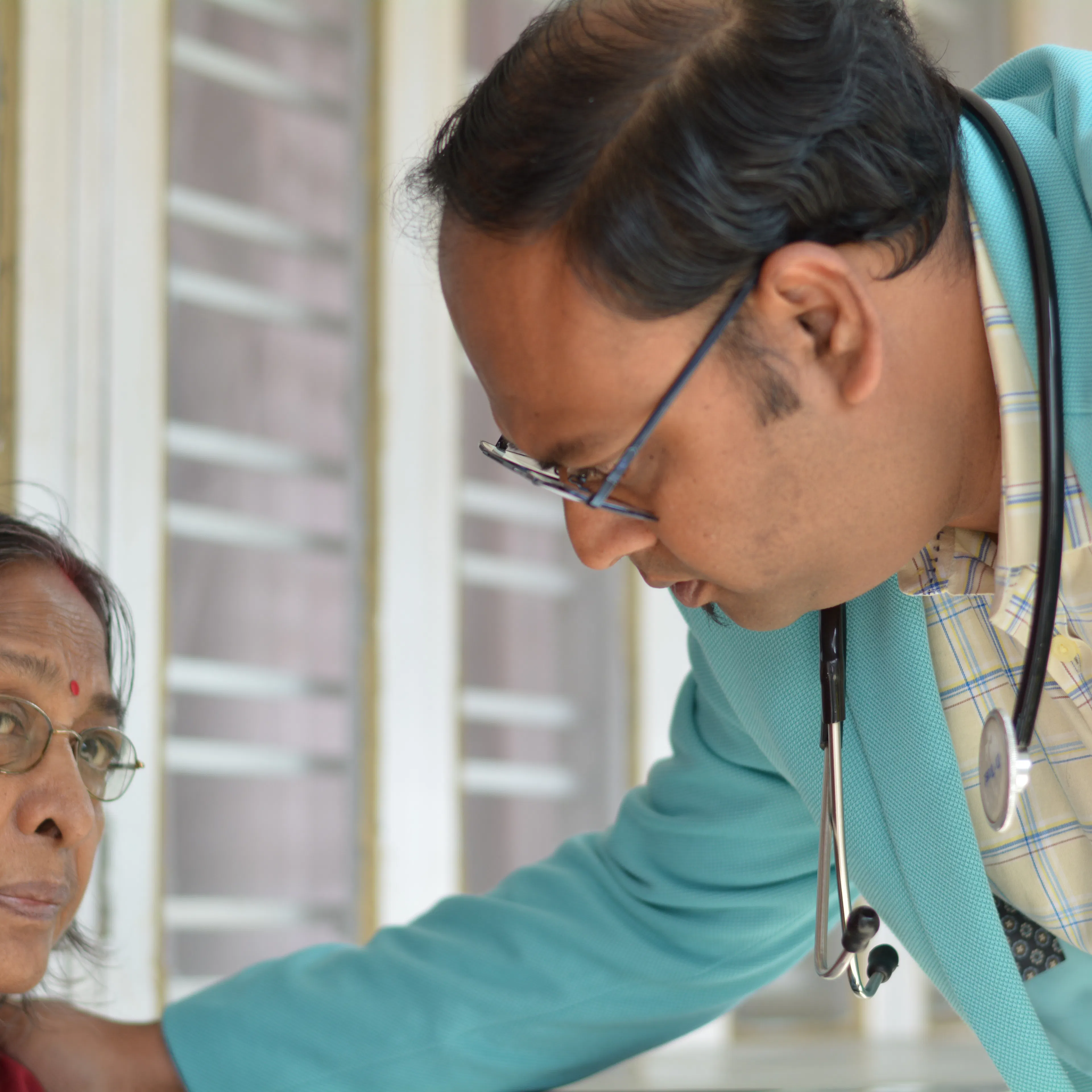 Doctor examining an elderly woman at the first neurophysiotherapy assessment