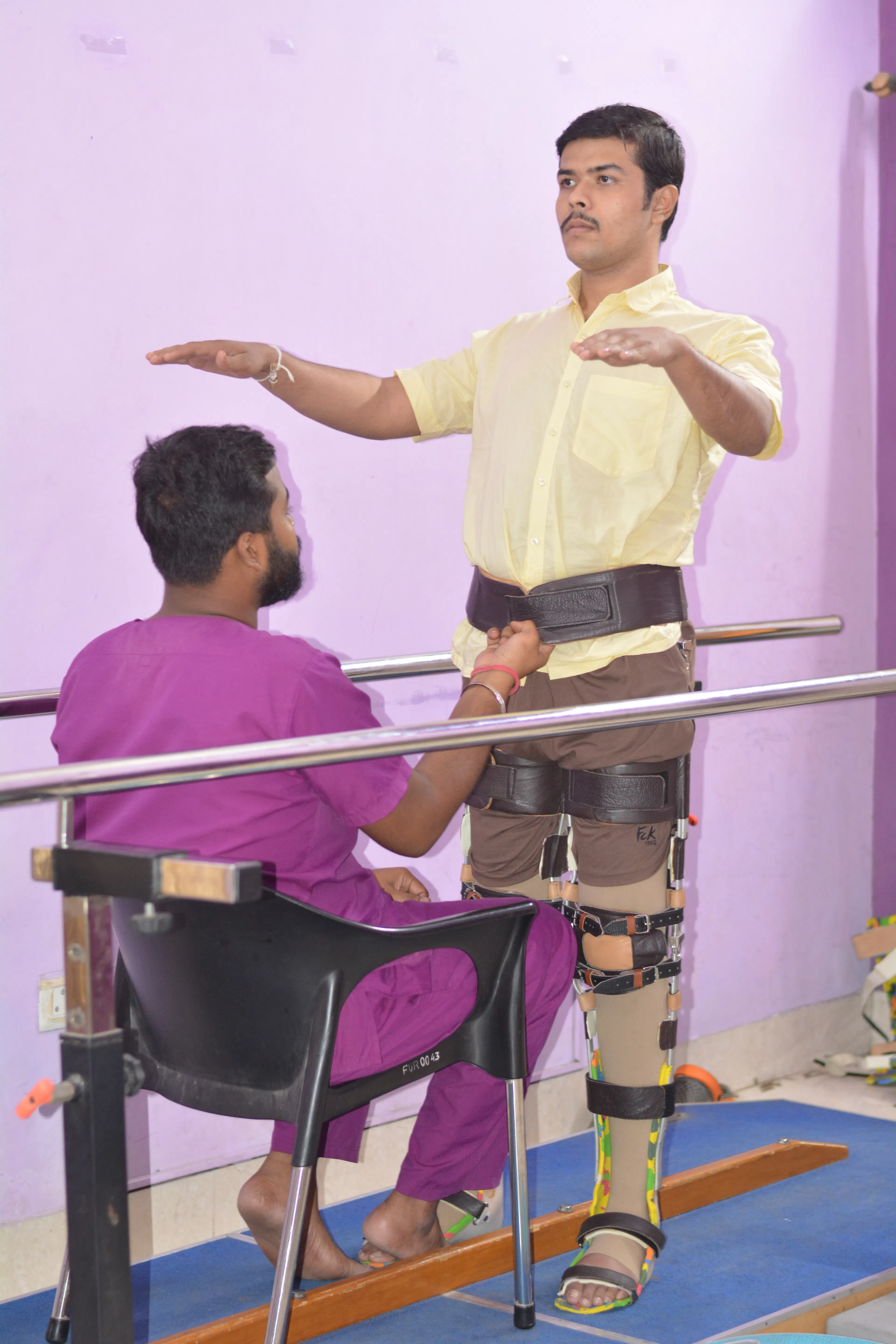Physiotherapist guiding a man in knee braces through arm reaches at parallel bars
