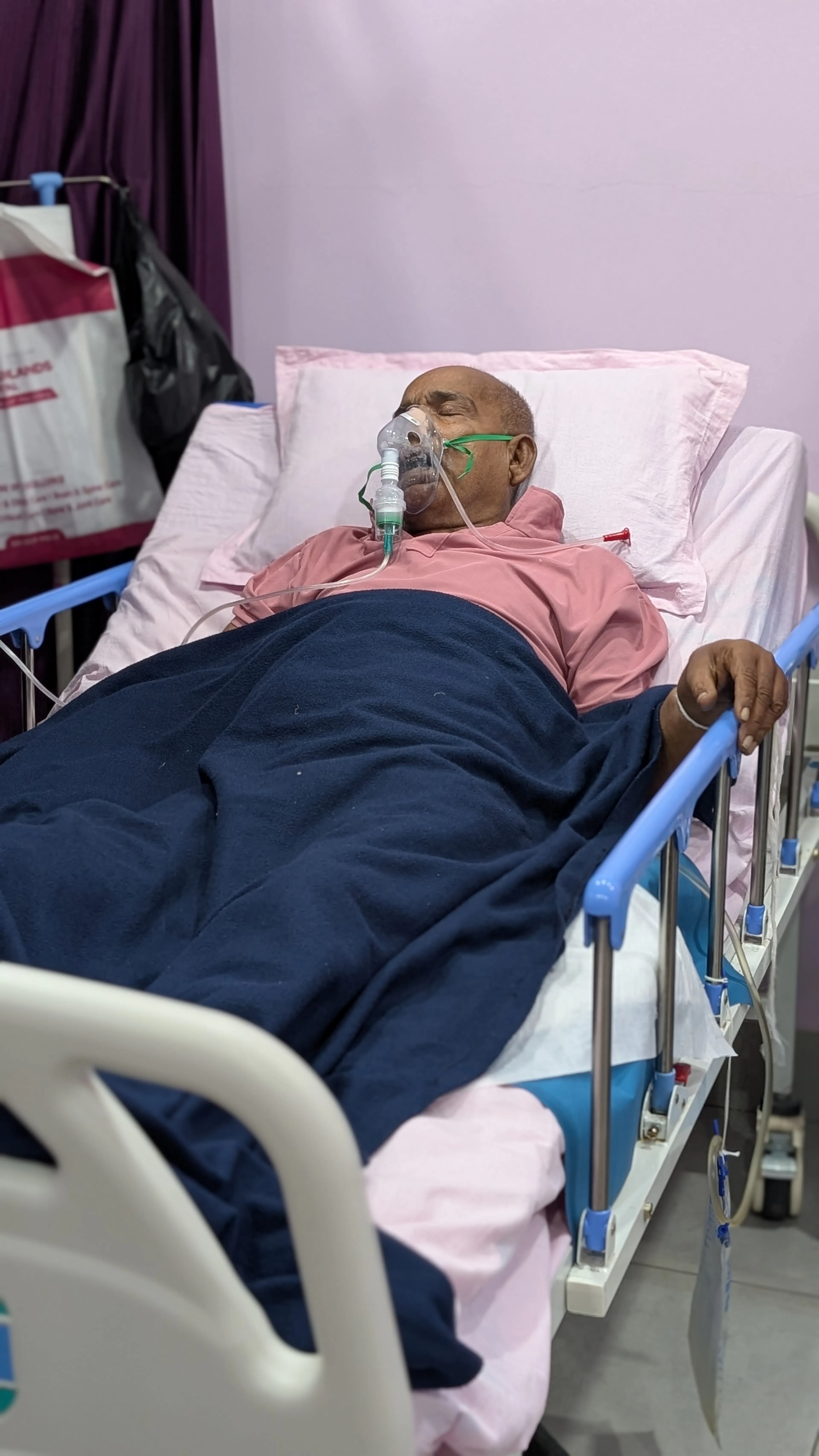 Older man resting in a hospital bed with oxygen support before moving on to inpatient rehabilitation
