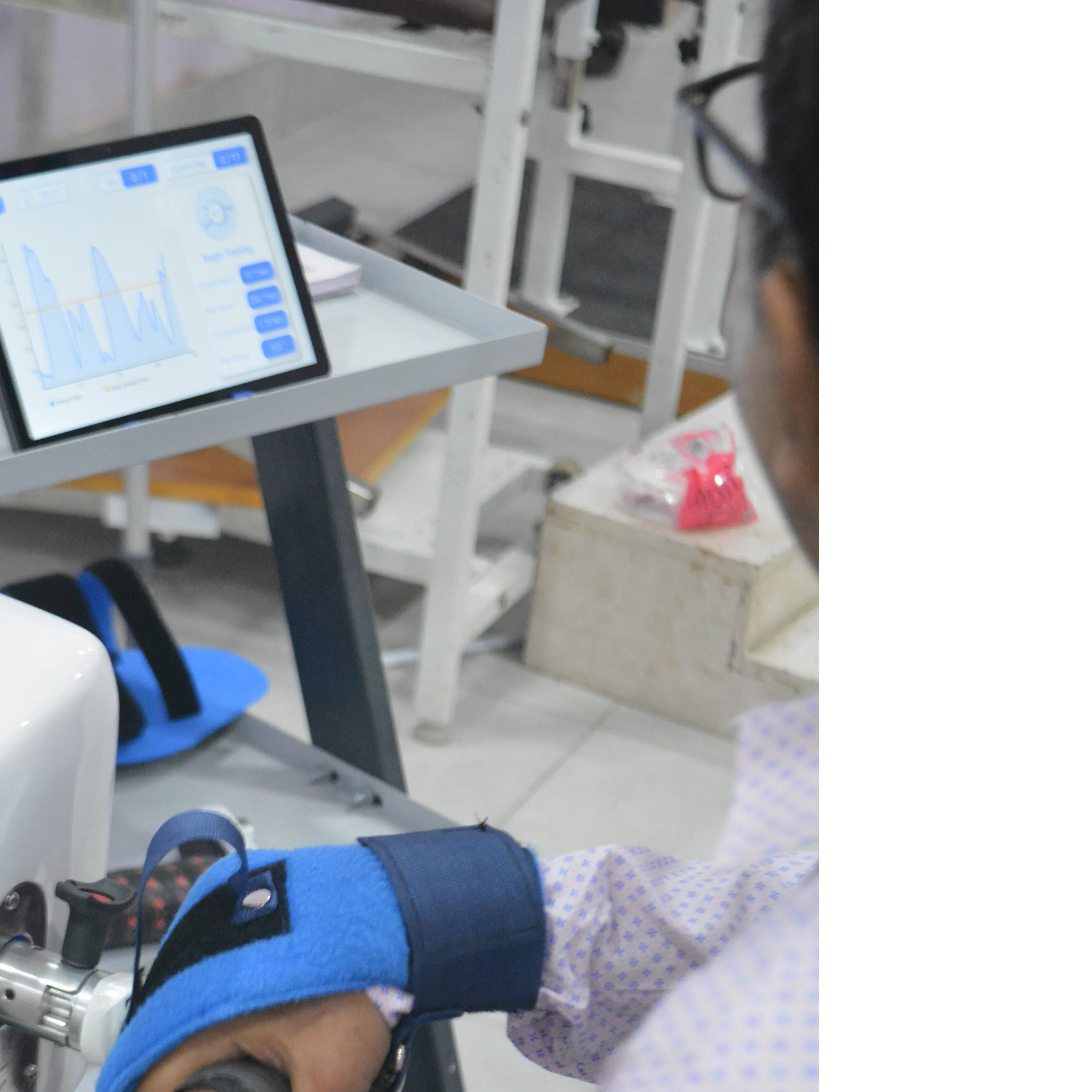 Hand strapped into a robotic hand and wrist device connected to a tablet game during digital therapy