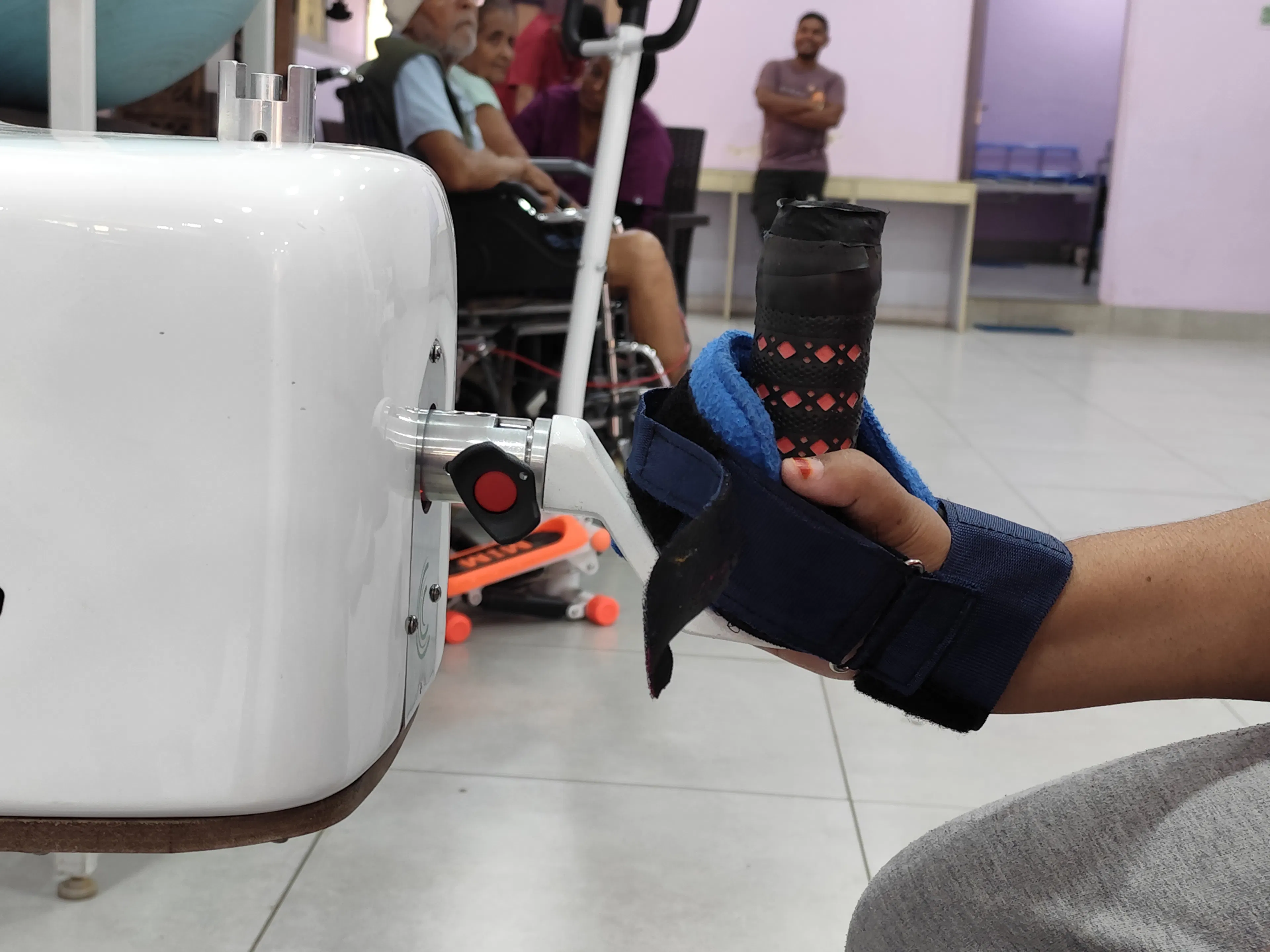 Patient forearm strapped into a wrist and hand robot during a robotic therapy session