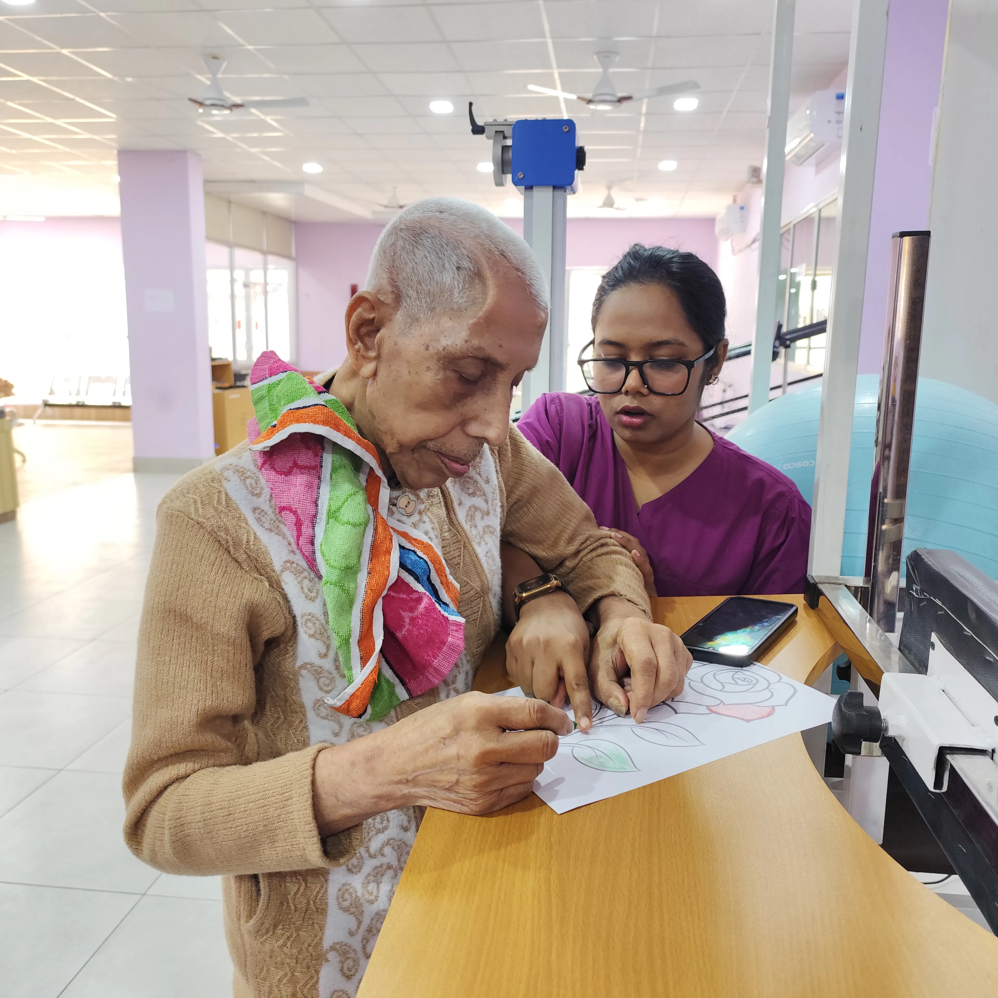 Older woman writing a worksheet with her therapist during a speech therapy session