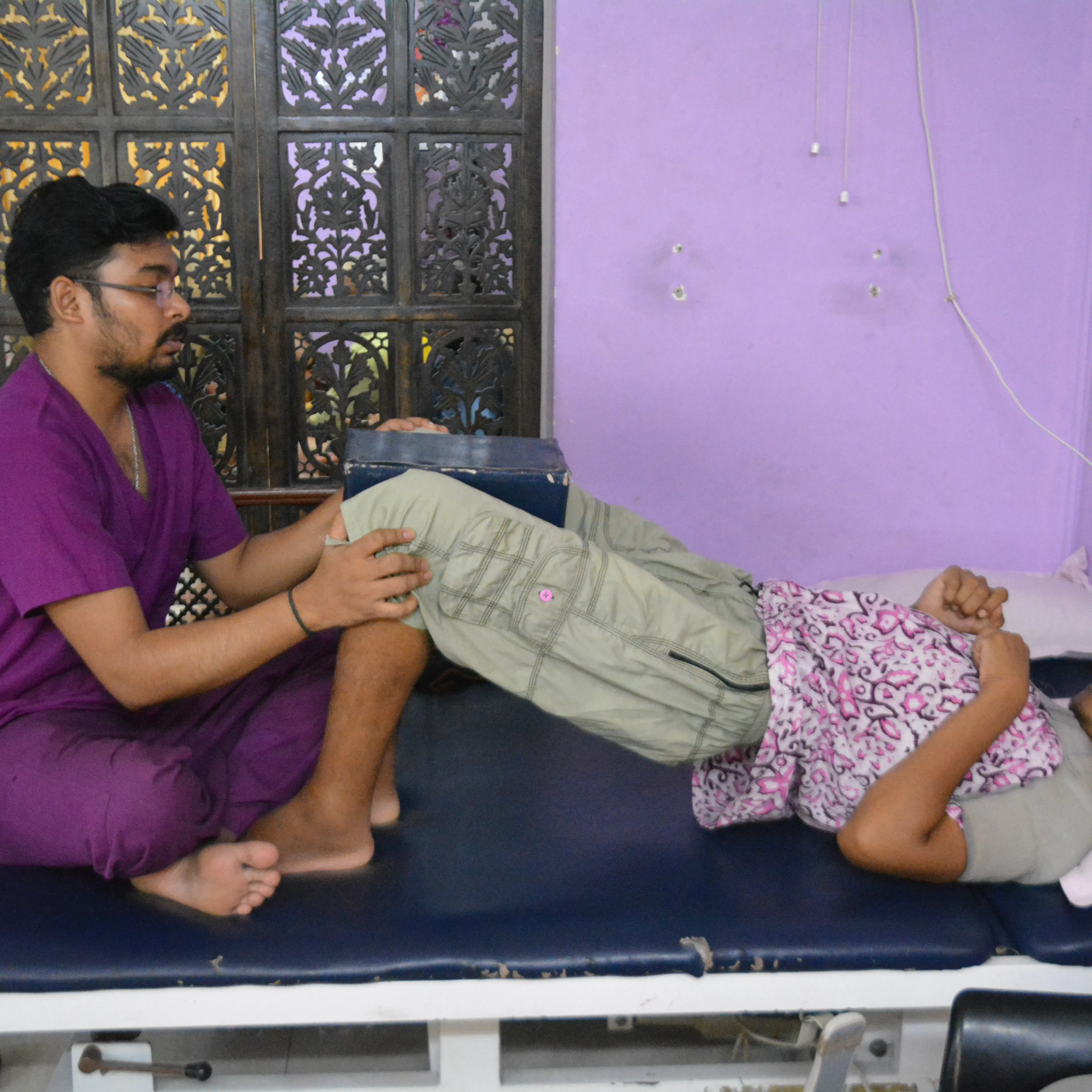 Therapist moving a woman's leg through its range to measure stiffness