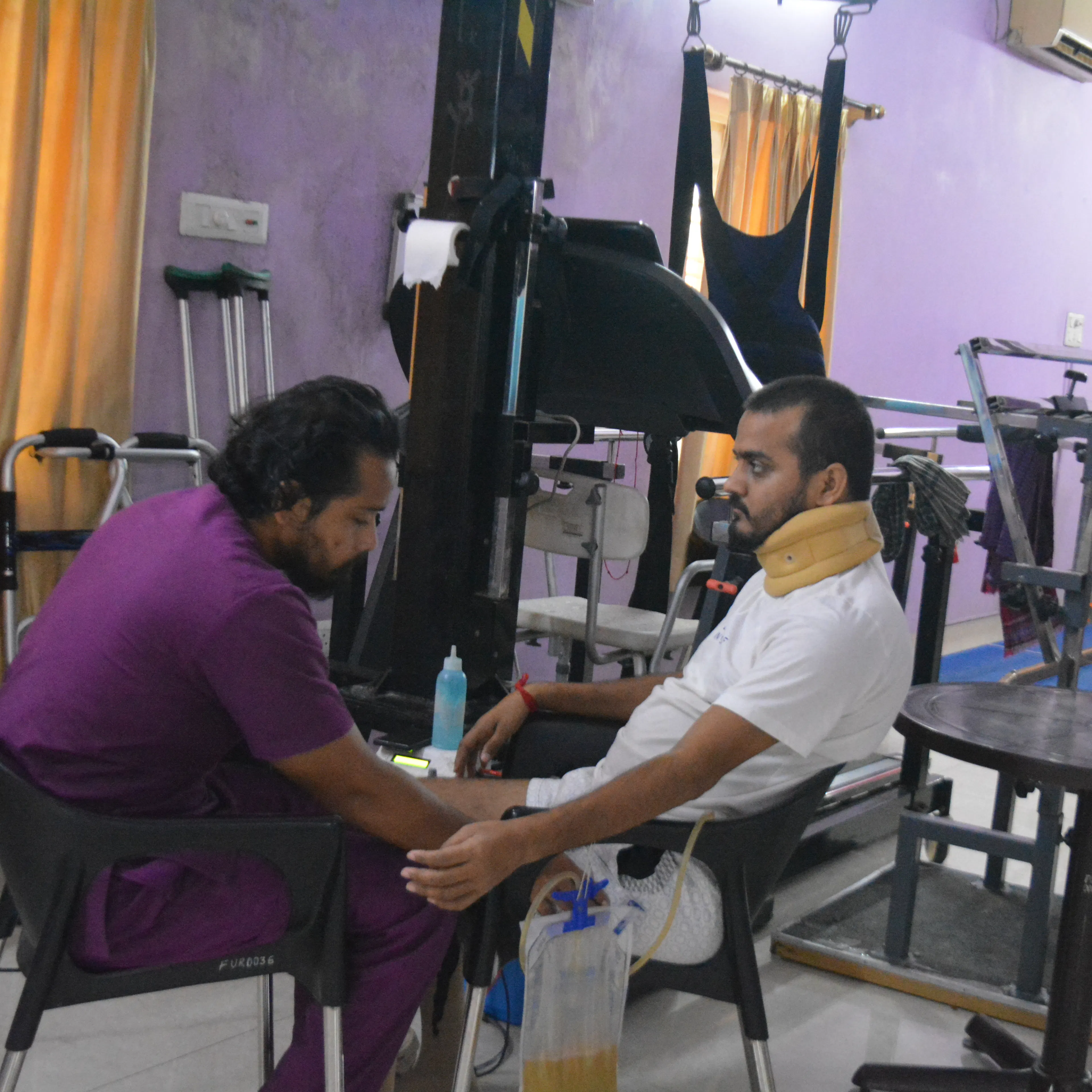 Therapist working on a patient's arm during daily therapy in the rehab gym