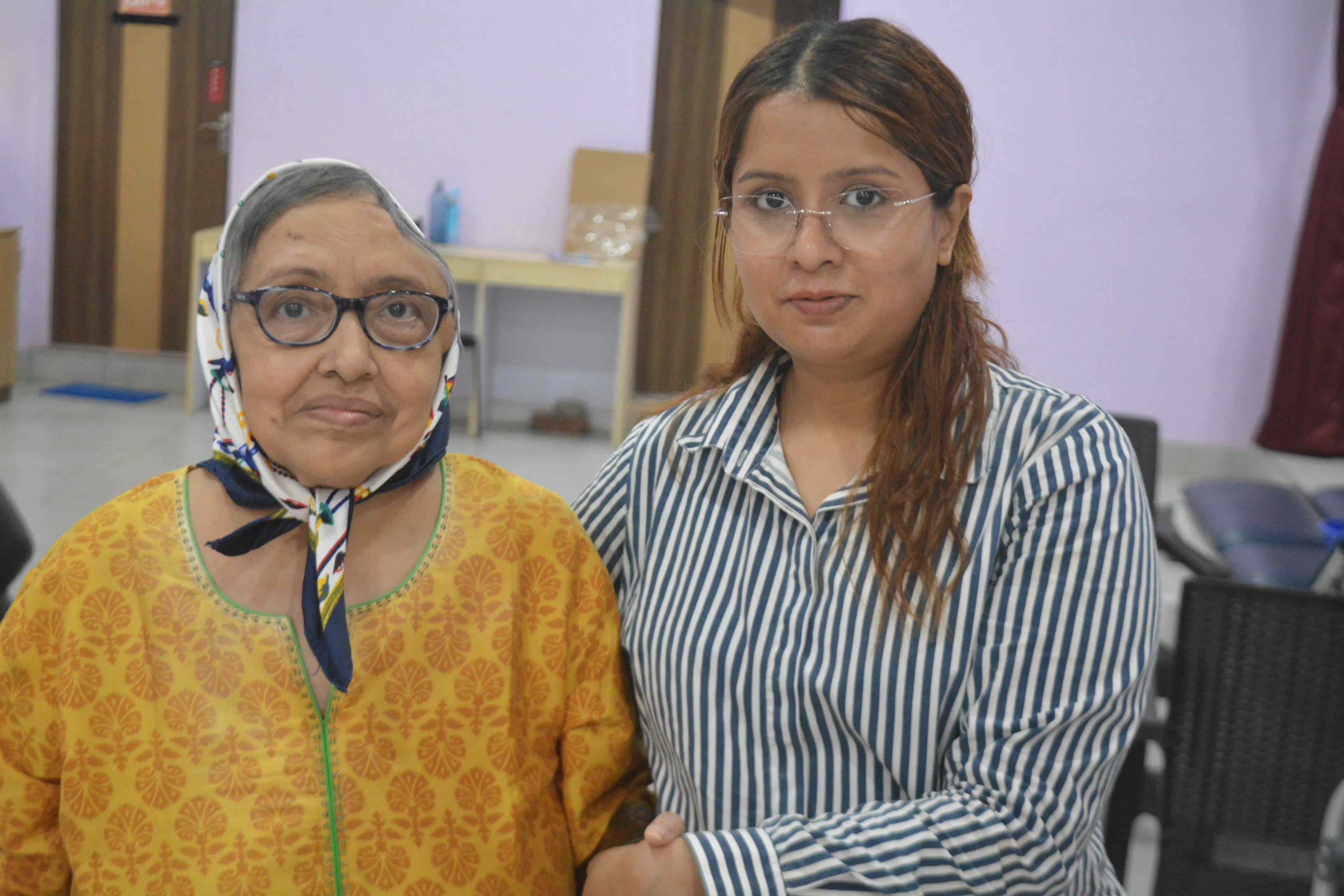 Older woman sitting with her daughter, a family member supporting communication at home
