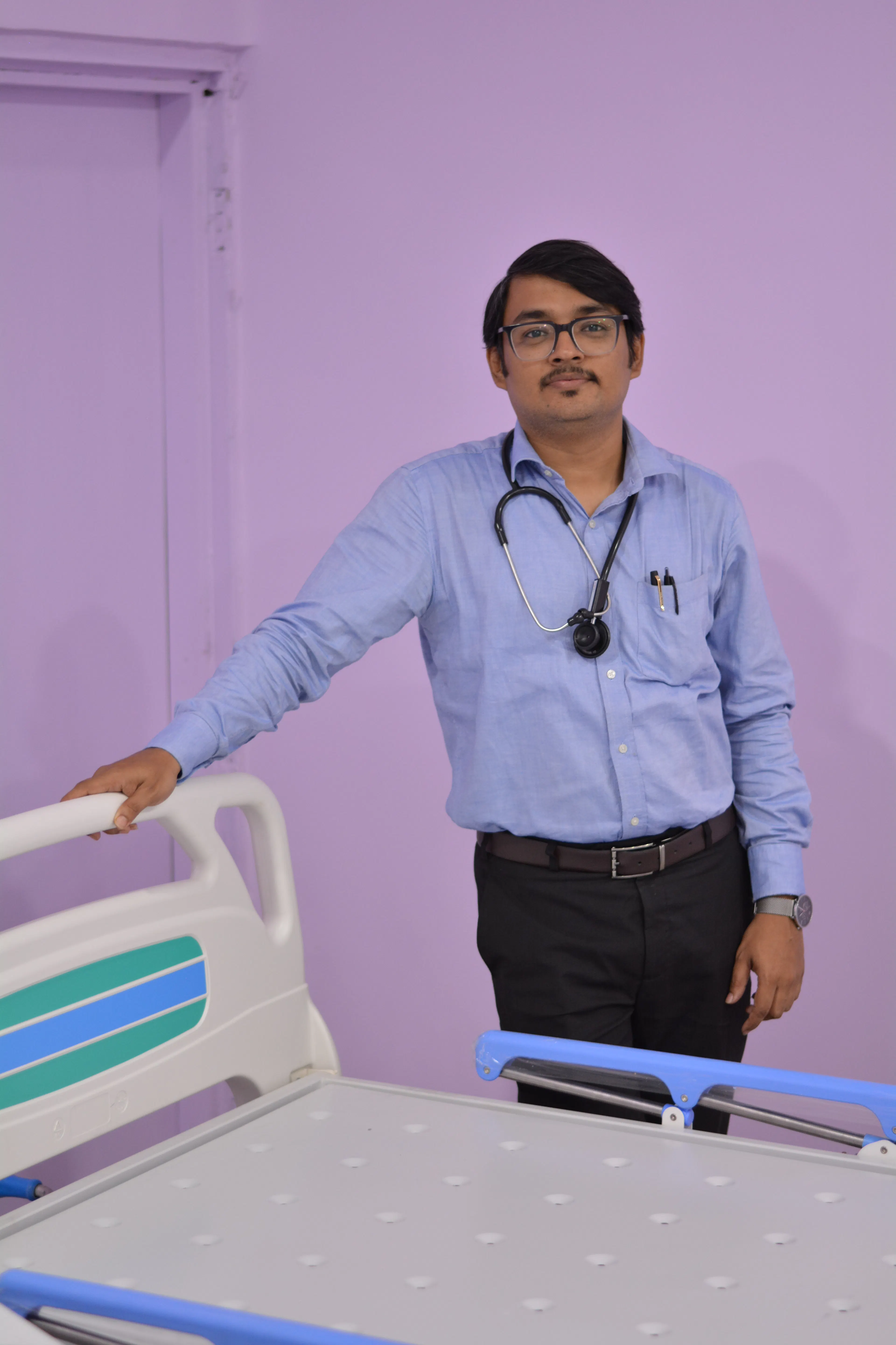 Doctor with a stethoscope standing beside a hospital bed