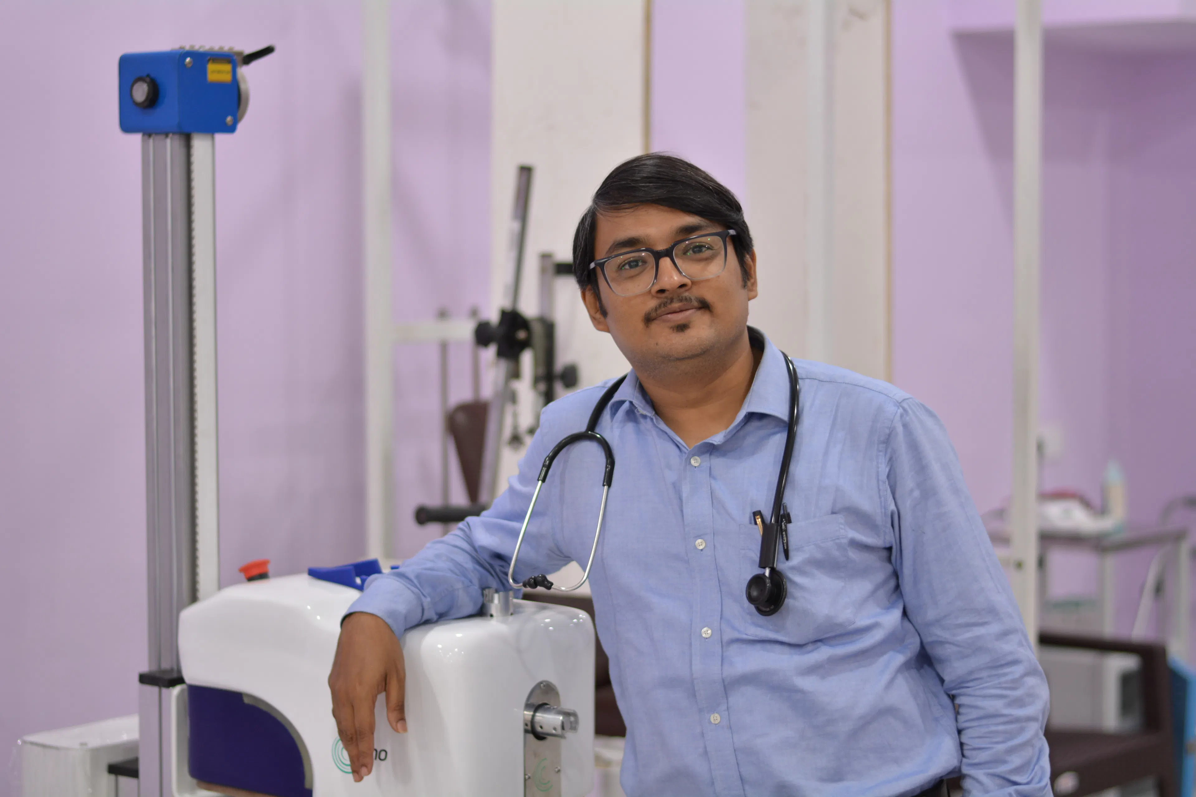 Rehabilitation doctor beside a therapy device, overseeing safe robotic rehabilitation