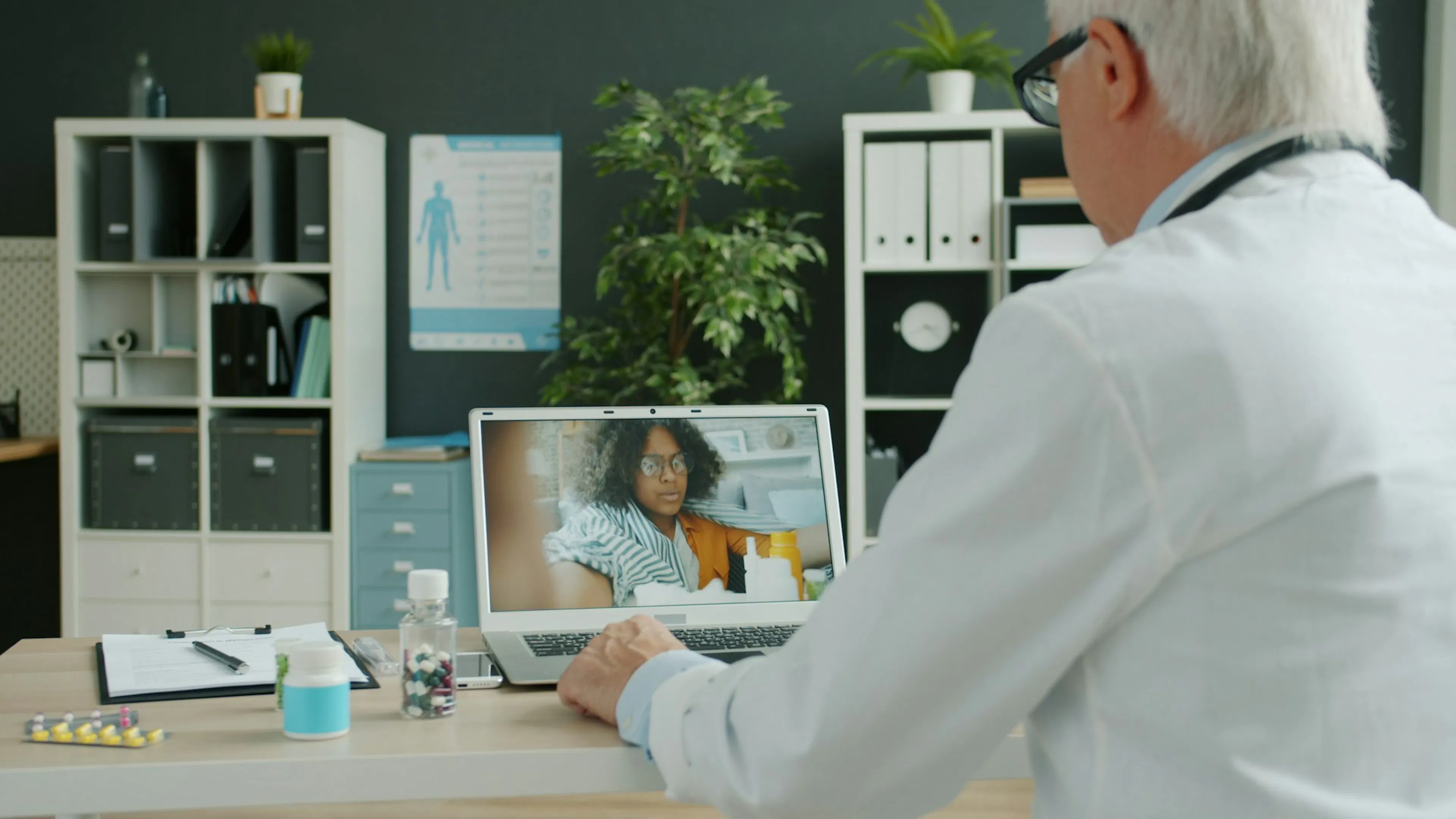 Doctor talking with a patient at home over a video call, as in telerehabilitation check-ins