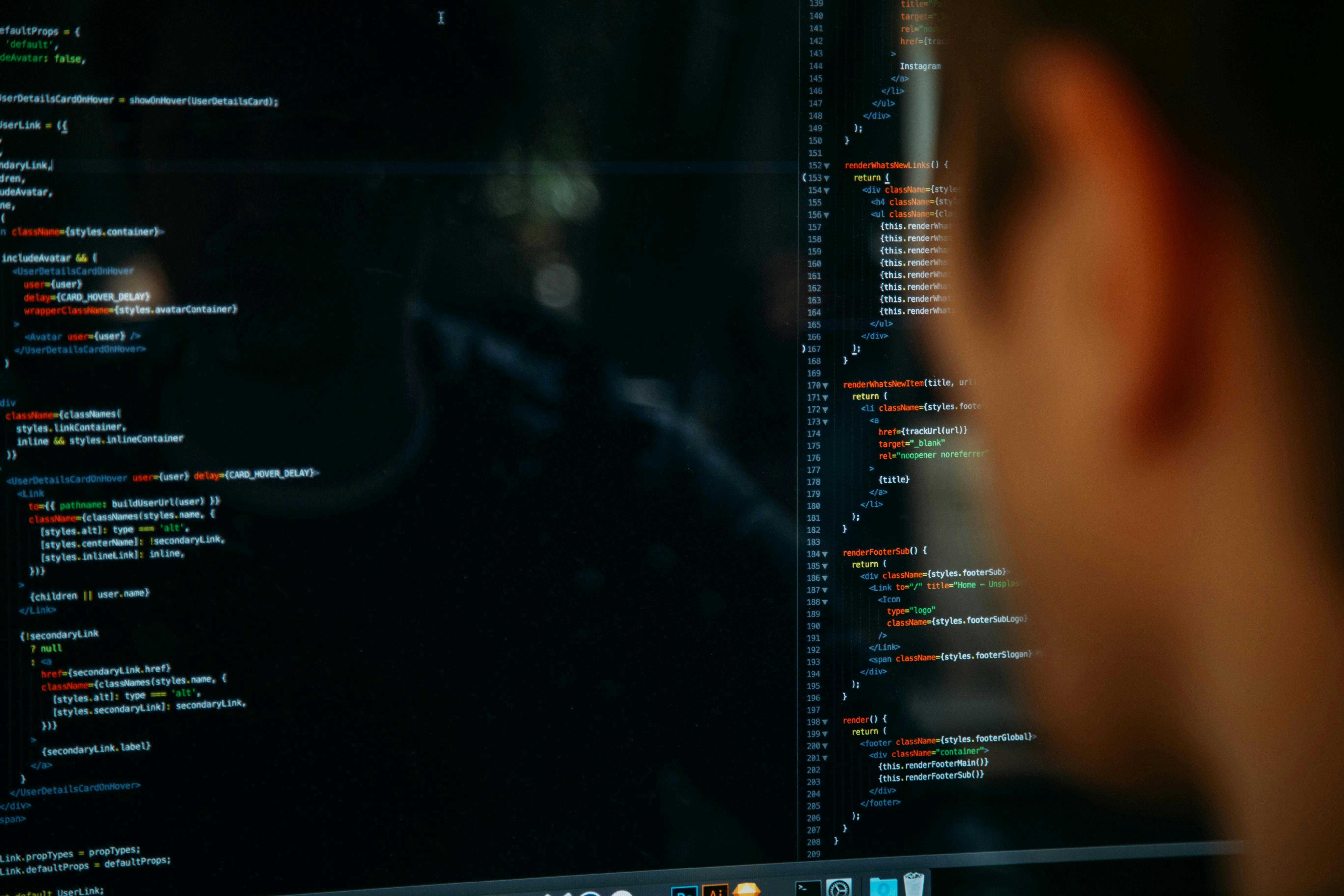 A person looking at a computer screen displaying JavaScript code with syntax highlighting in a dark-themed text editor.
