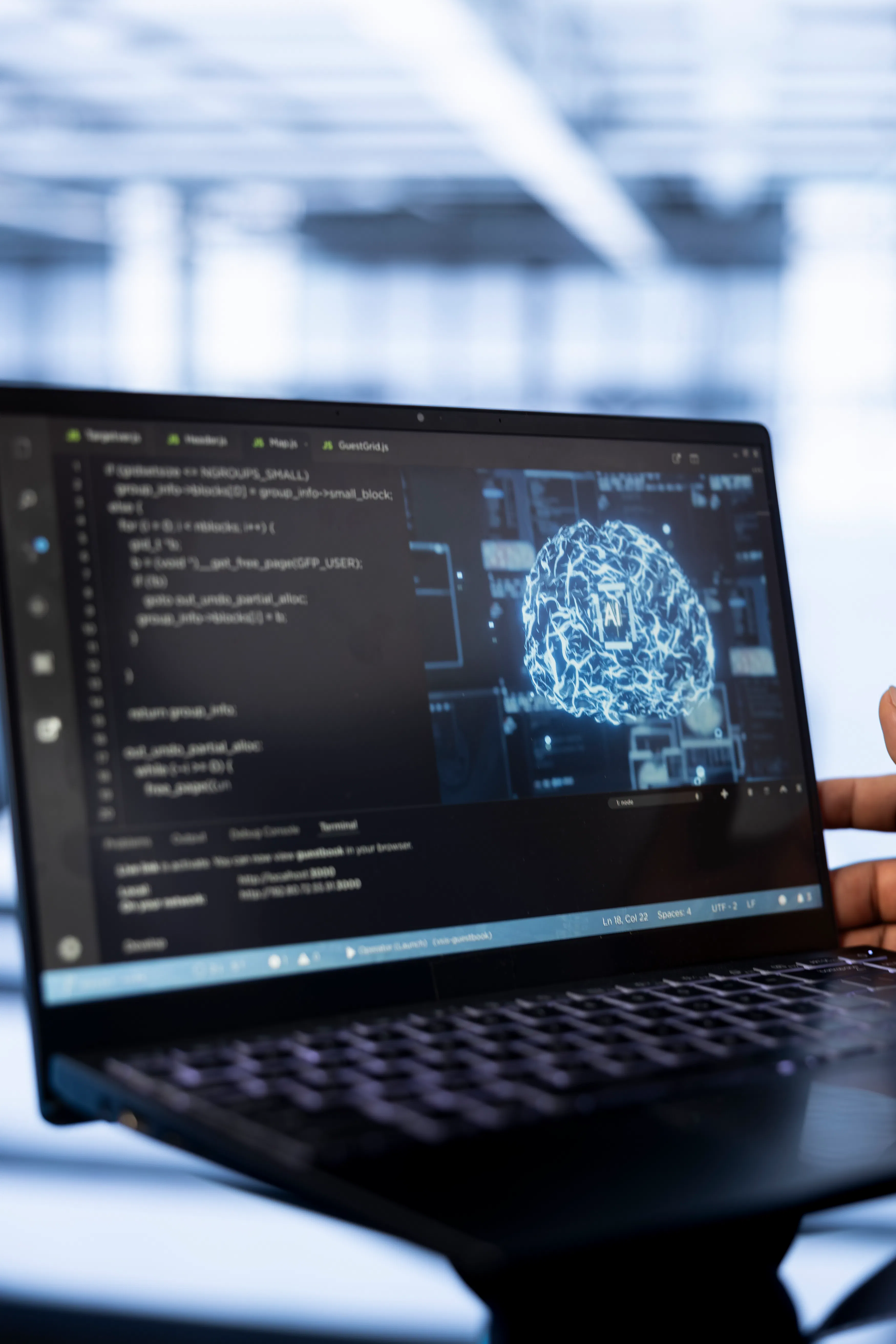 Close-up of a laptop screen with code and a digital brain icon labeled "AI" on the right. A hand points to the screen, suggesting tech engagement.