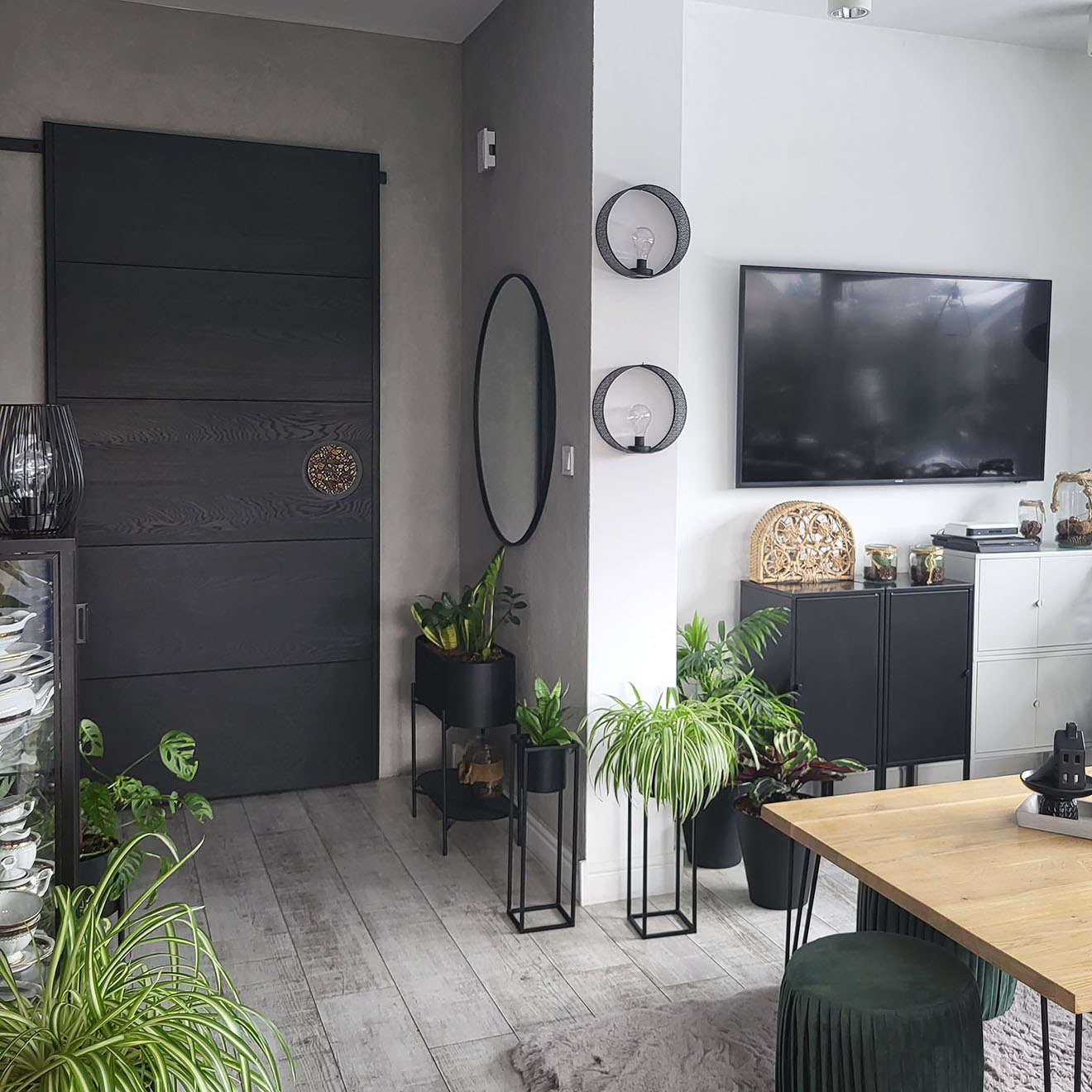 Schwarze Schiebetüren in einem modernen Wohnzimmer, das in grauen Farben mit schwarzen Accessoires dekoriert ist