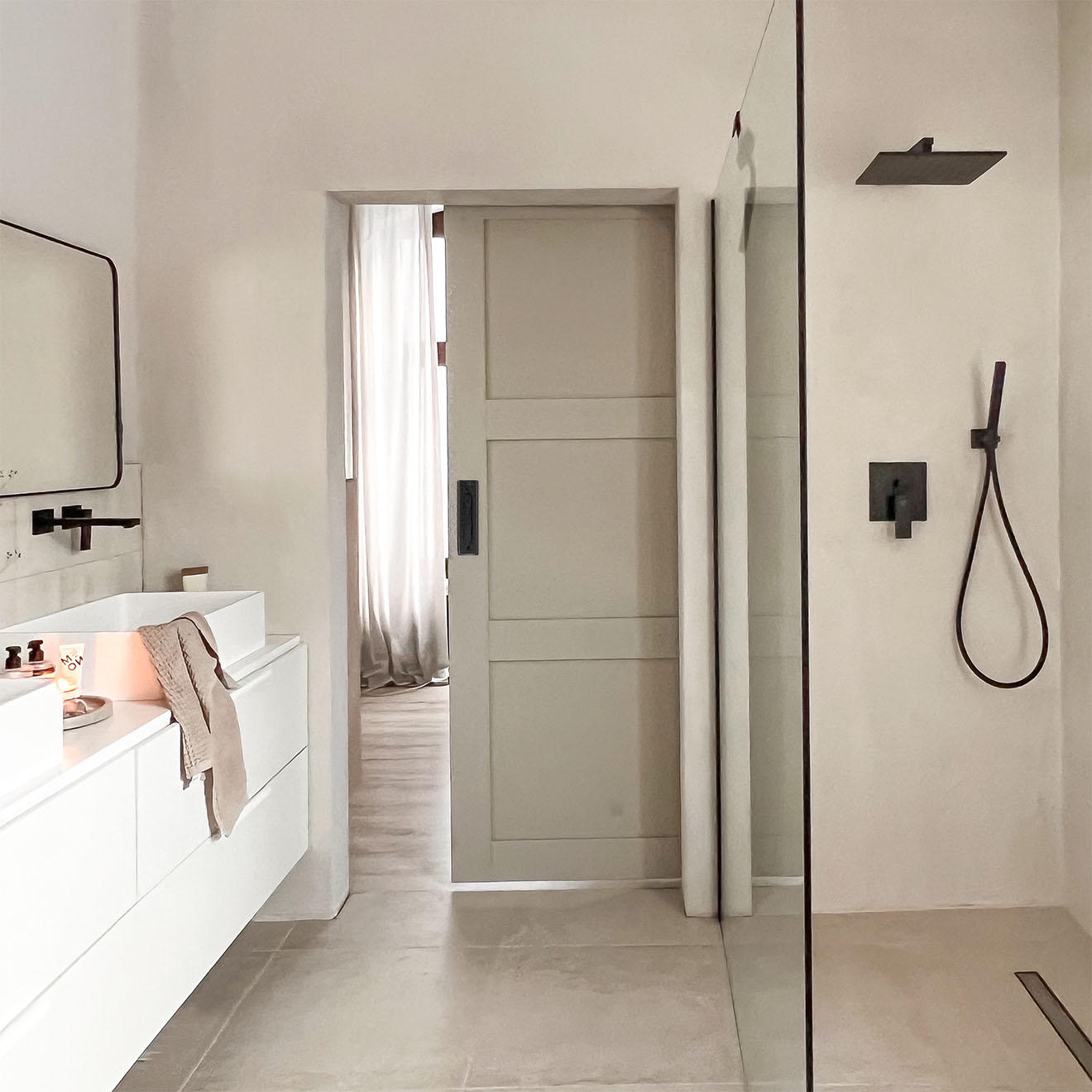 Badezimmer in Grau- und Beigetönen mit schwarzen Accessoires