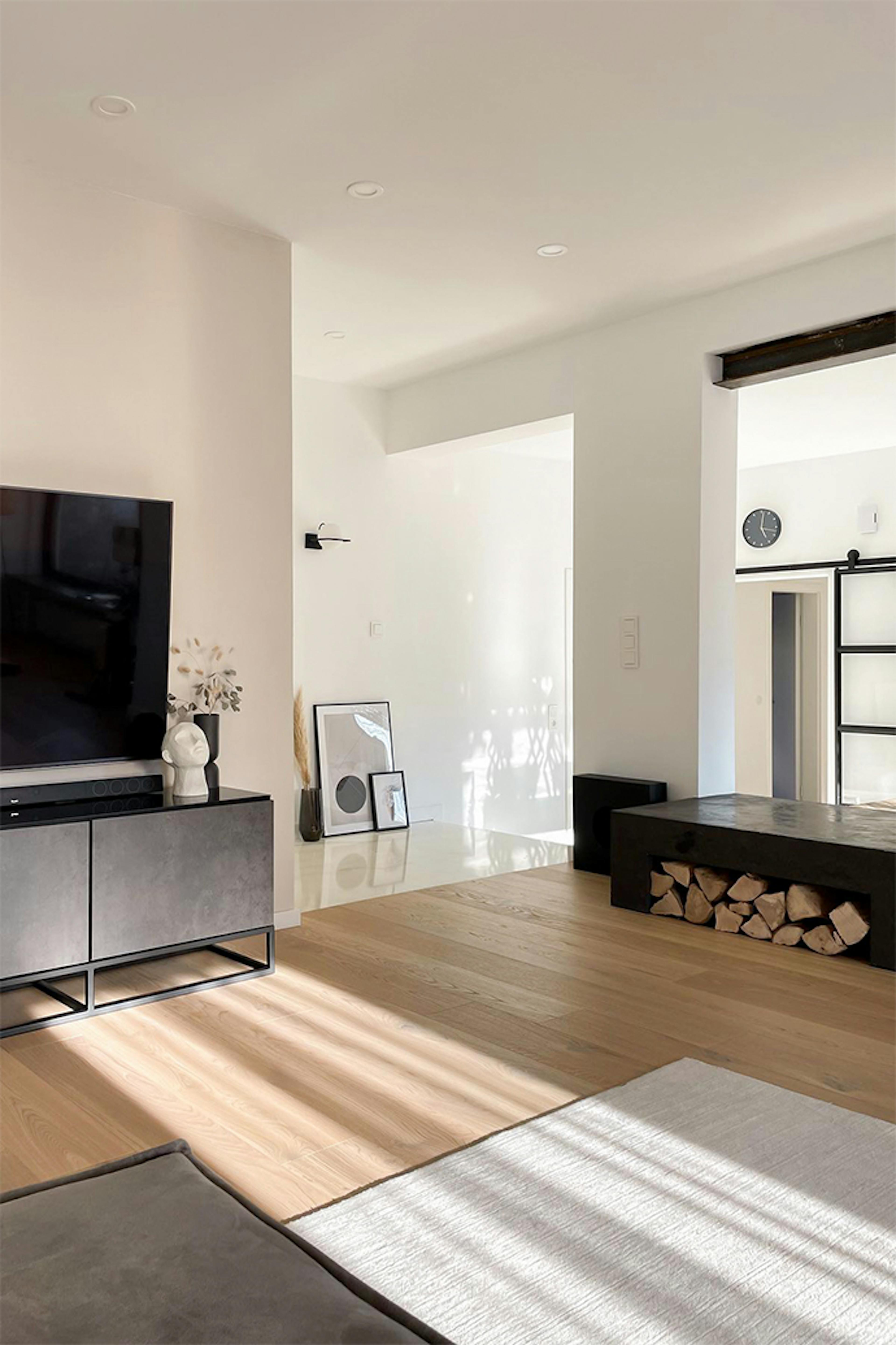 offener Wohnraum, geräumiges minimalistisches Wohnzimmer, schwarze Metallmöbelverkleidung, minimalistische Dekorationen, weiße Wände im Wohnzimmer