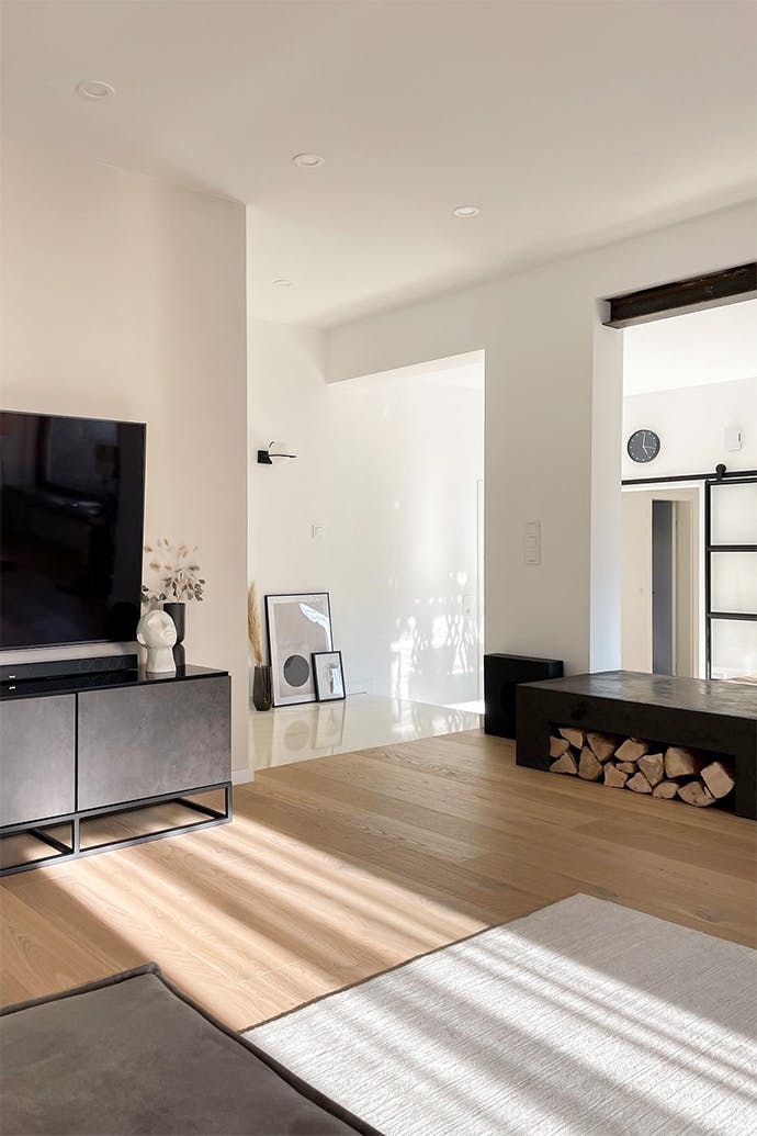 offener Wohnraum, geräumiges minimalistisches Wohnzimmer, schwarze Metallmöbelverkleidung, minimalistische Dekorationen, weiße Wände im Wohnzimmer