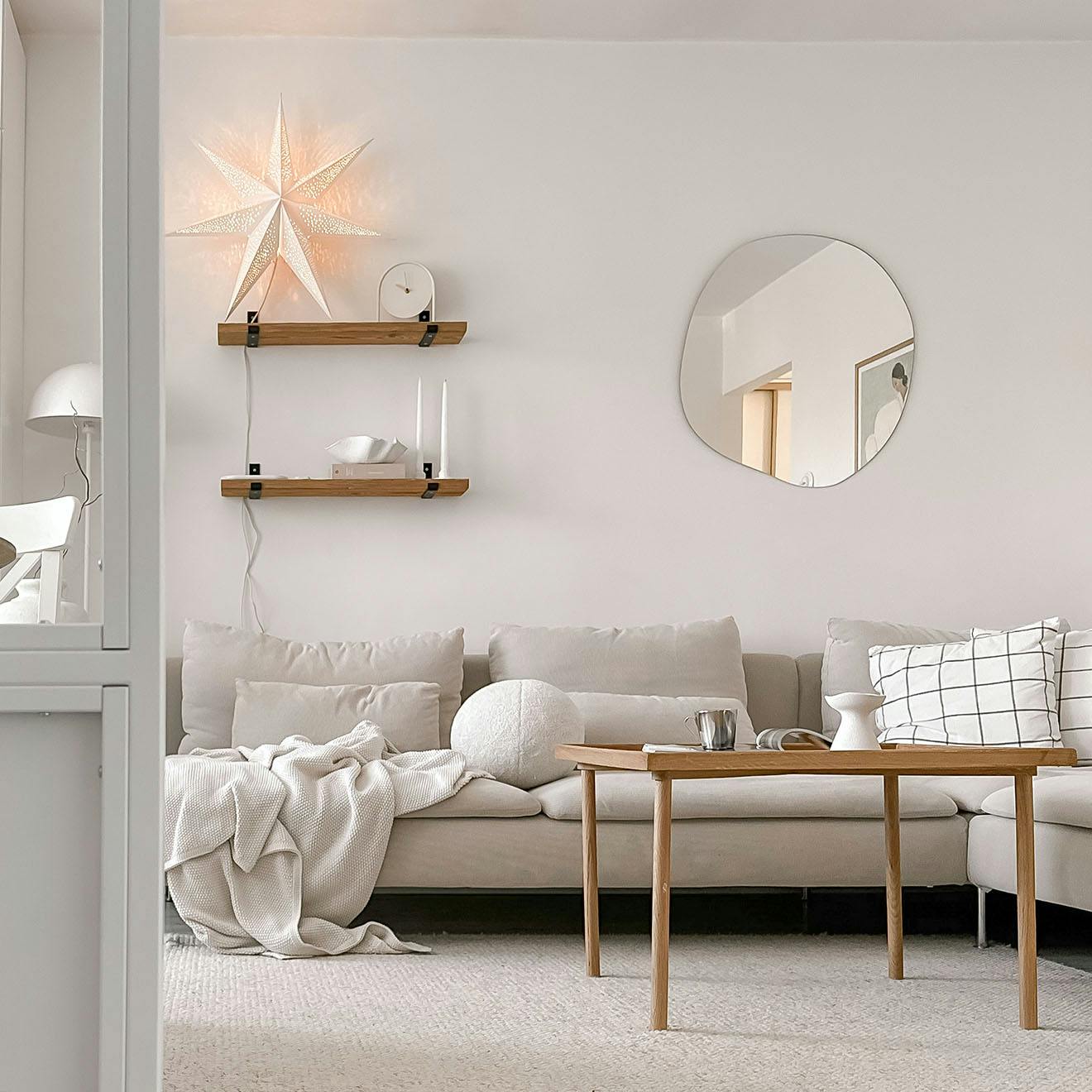 ein Sofa in einem neutralen Farbton, ein Couchtisch aus Holz in einem hellen Wohnzimmer in einem Wohnblock