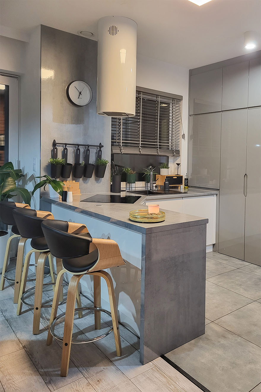 blat kuchenny z hokerami oddzielający nowoczesną kuchnię w kolorach szarości