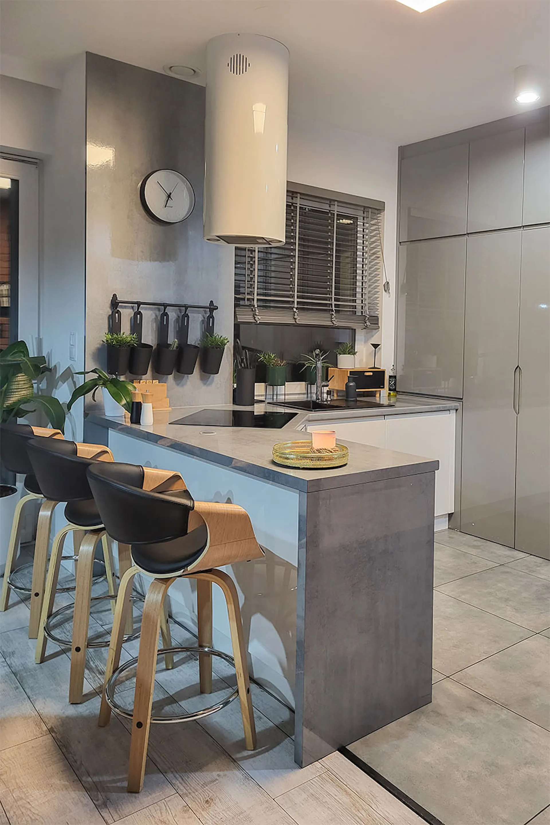 blat kuchenny z hokerami oddzielający nowoczesną kuchnię w kolorach szarości