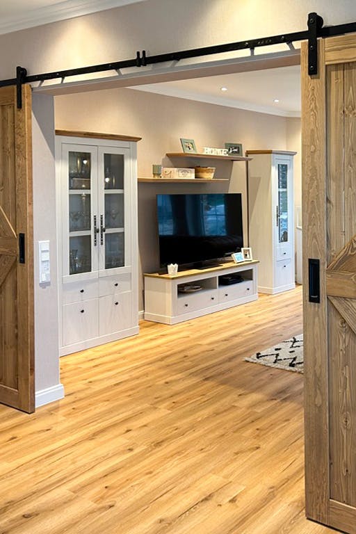 offene Schiebetür, die eine TV-Ecke im Wohnzimmer freigibt