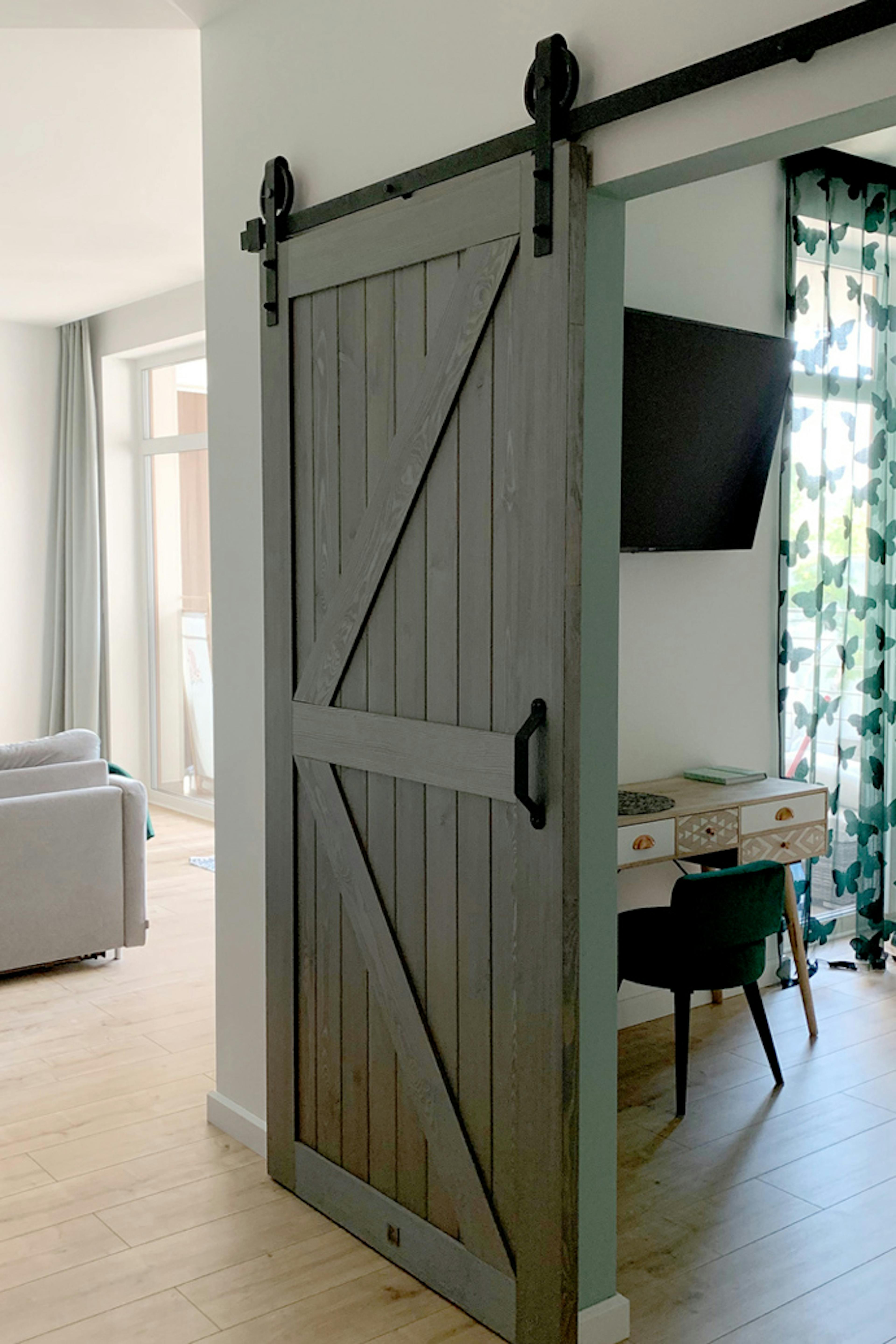 Holzschiebetüren, Scheunen-Schiebetüren, Schiebetür holz grau, goldene Accessoires im Innenraum, modernes Interieur, Schlafzimmerschiebetür