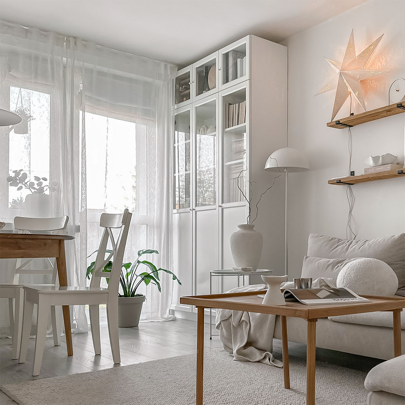 Couchtisch aus Holz, weißer Kleiderschrank mit Glasfronten im Wohnzimmer eines Wohnblocks