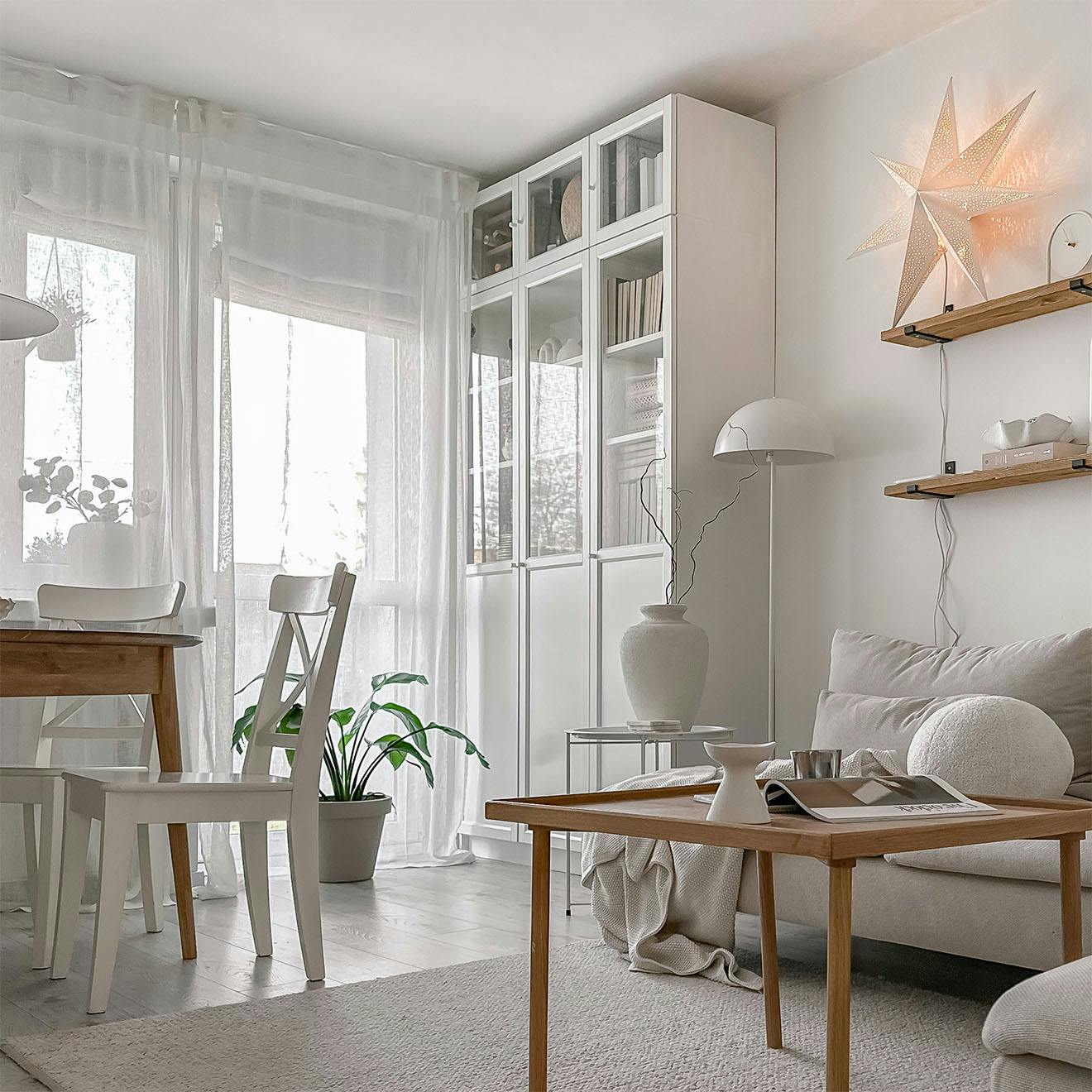 Couchtisch aus Holz, weißer Kleiderschrank mit Glasfronten im Wohnzimmer eines Wohnblocks