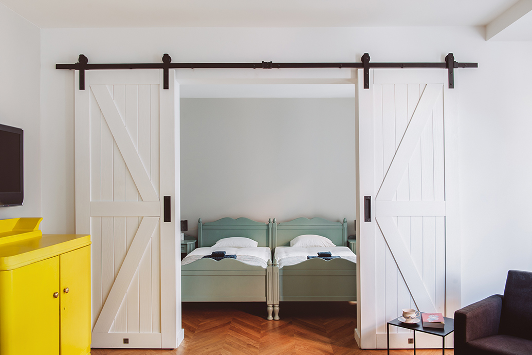 Weiße Doppelschiebetüren zum Schlafzimmer mit salbeifarbenem Queensize-Bett