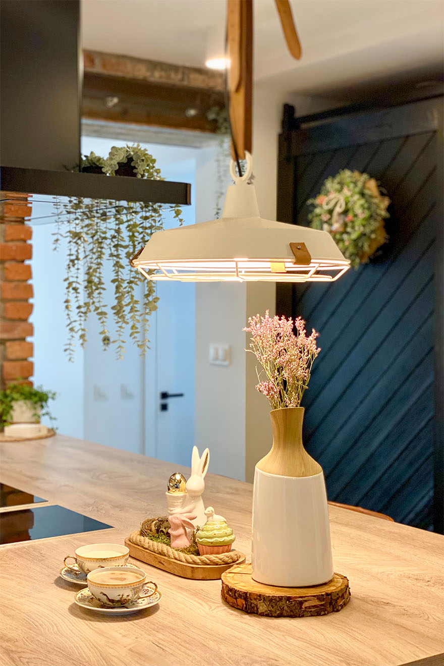 weiße Industrielampe über der Kücheninsel, schwarze Speisekammertür, Küche mit Speisekammer