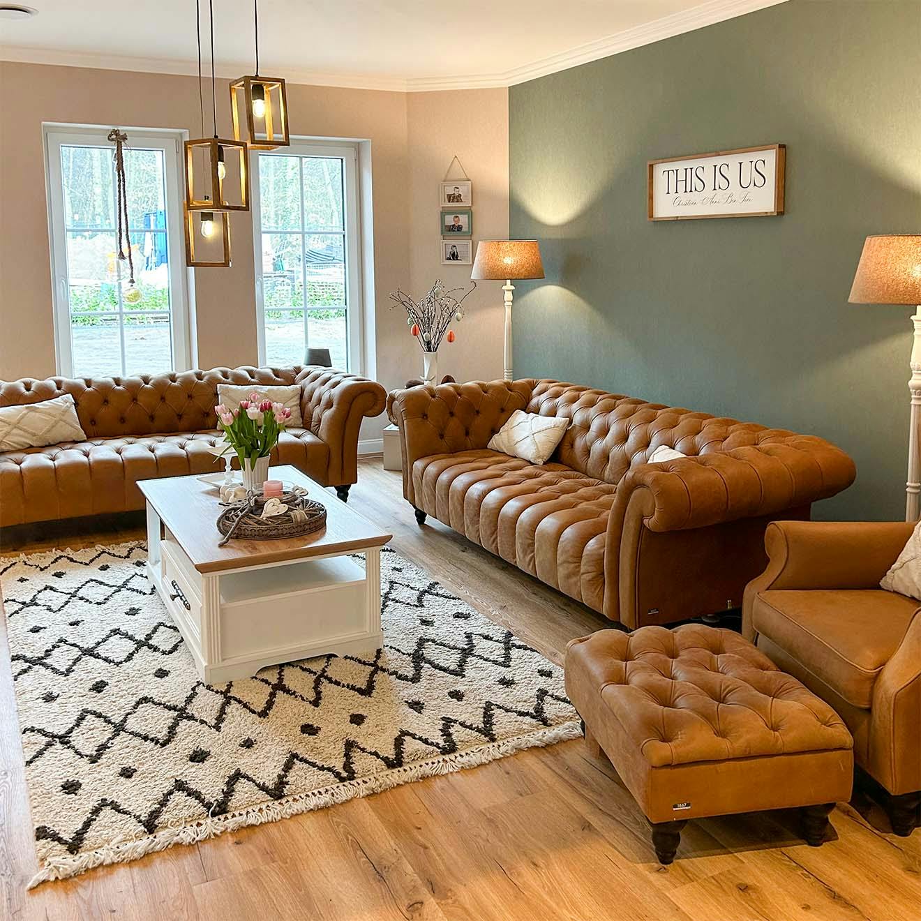 braun gesteppte Sofas und Sessel und ein weißer Couchtisch aus Holz in einer klassischen Wohnzimmeranordnung