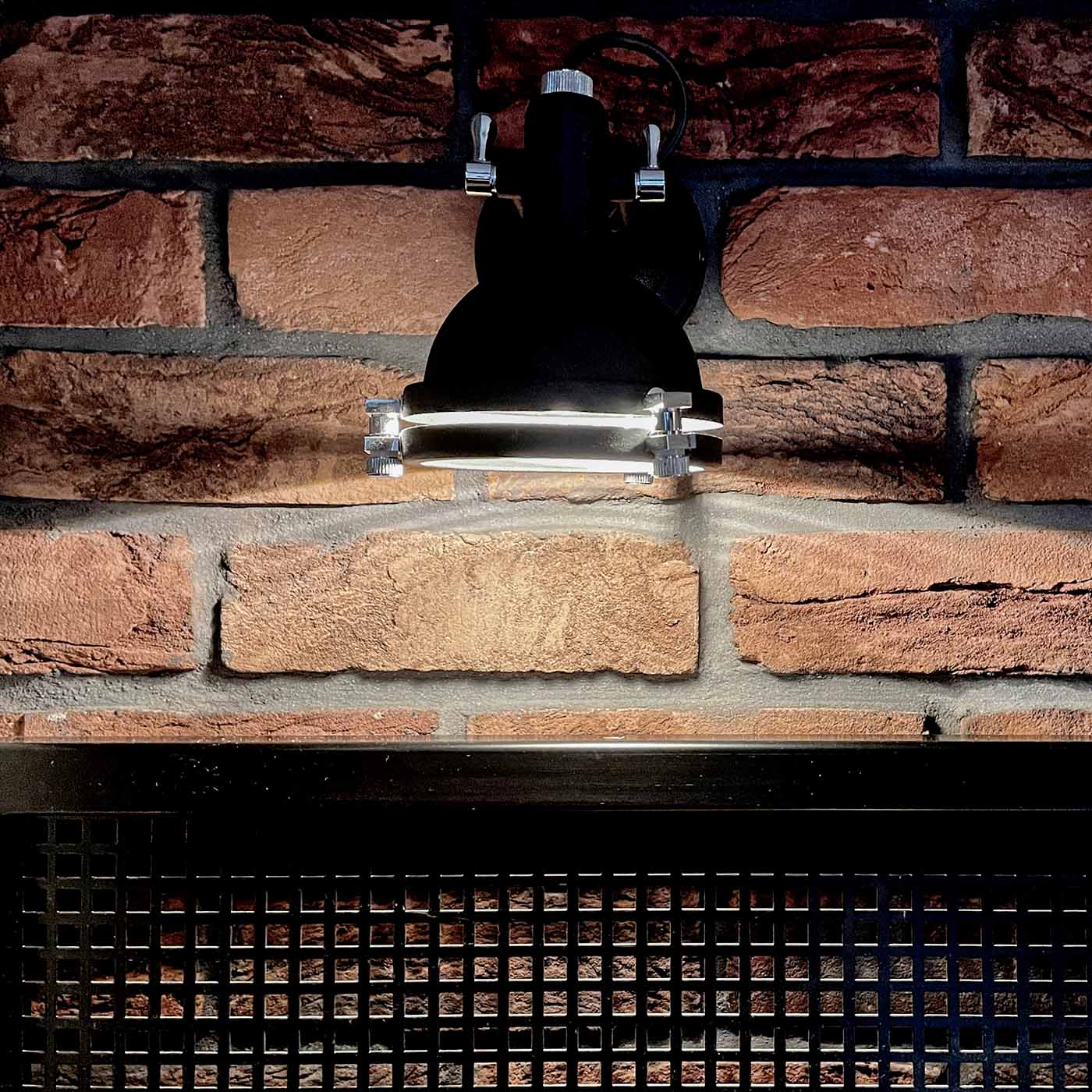 roter Backstein an der Wand im Schlafzimmer, Industrielampe an der roten Backsteinwand