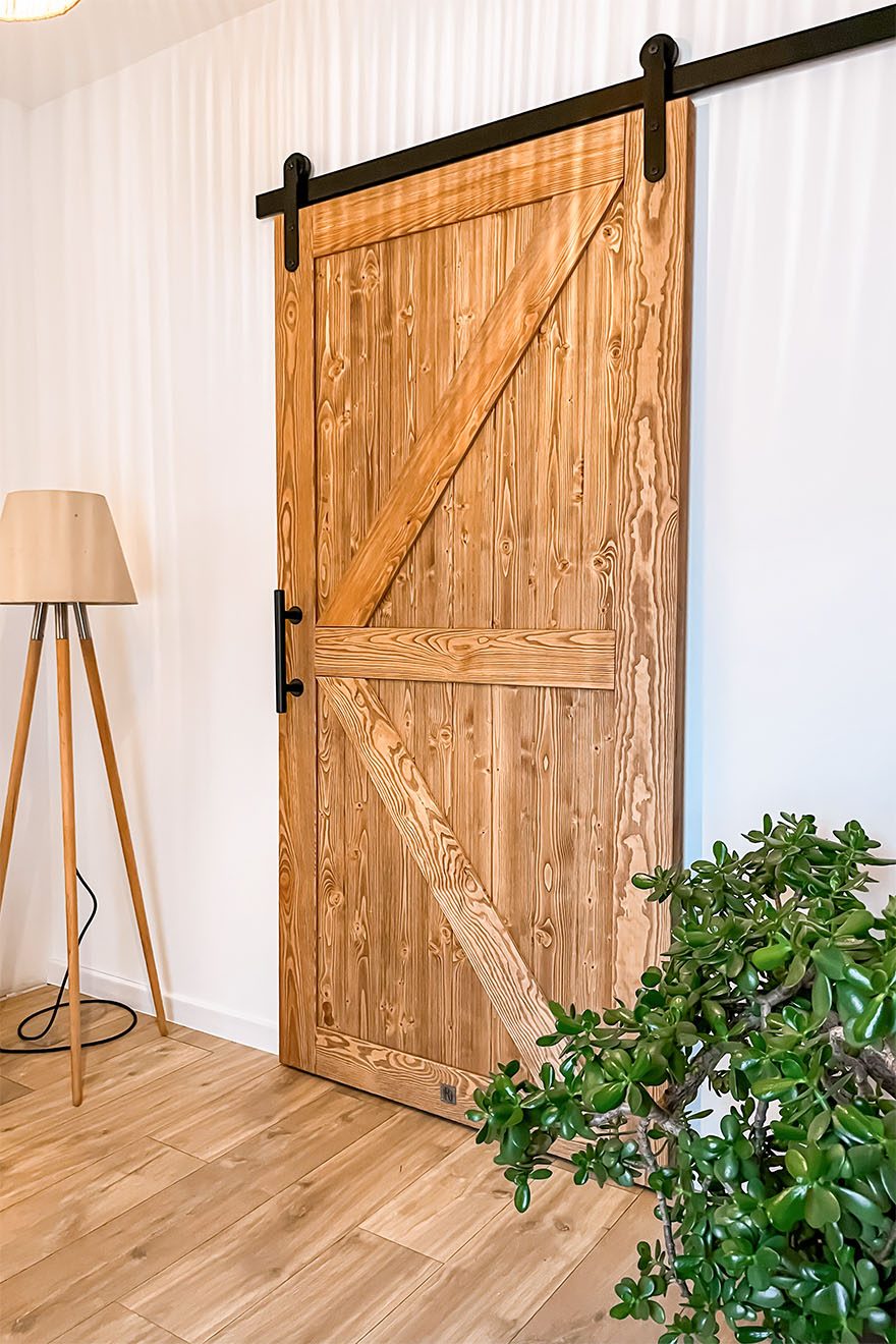 drewniane drzwi na czarnym systemie przesuwnym