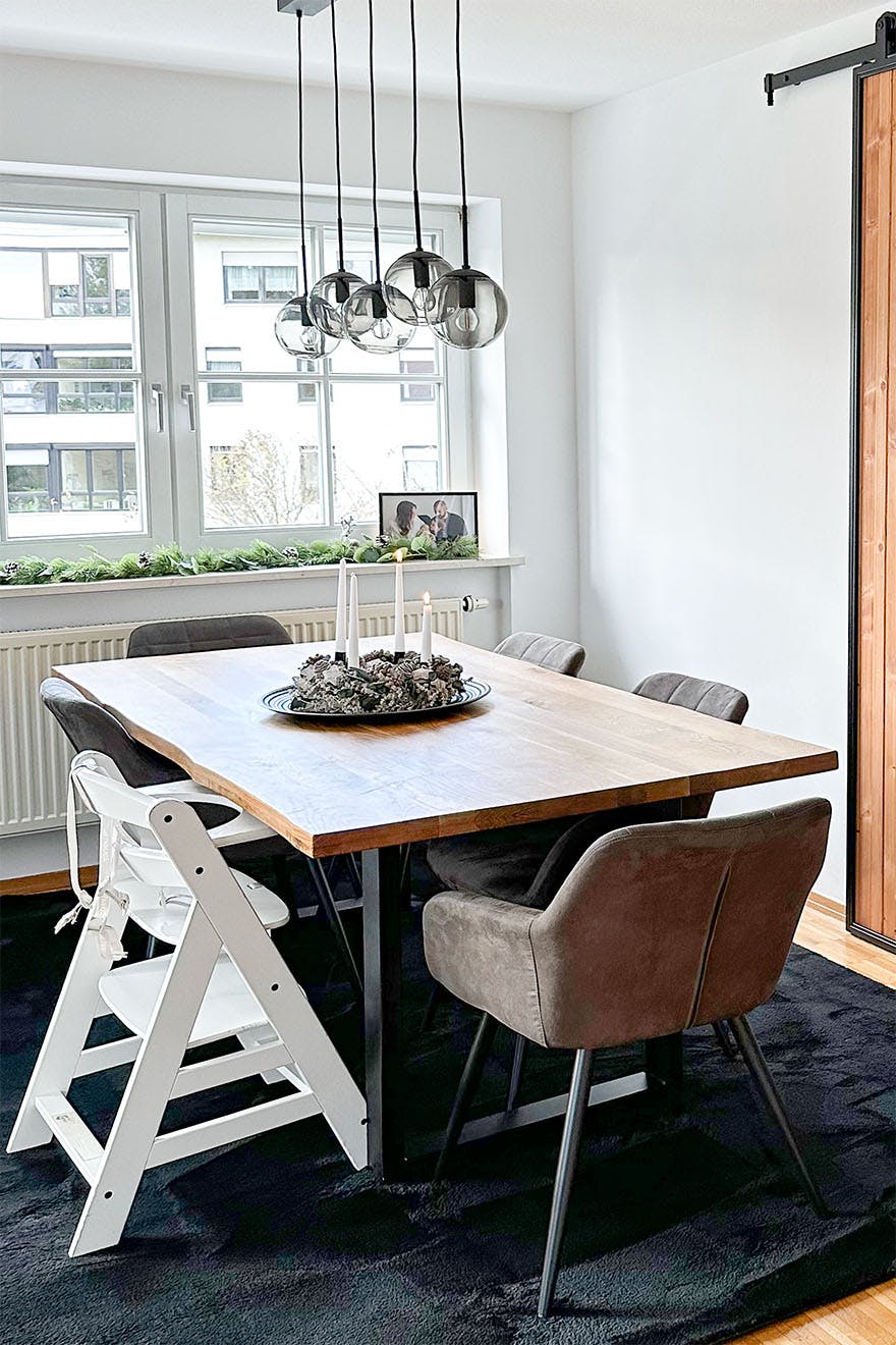 duży stół jadalniany z drewnianym blatem ustawiony obok okna w salonie