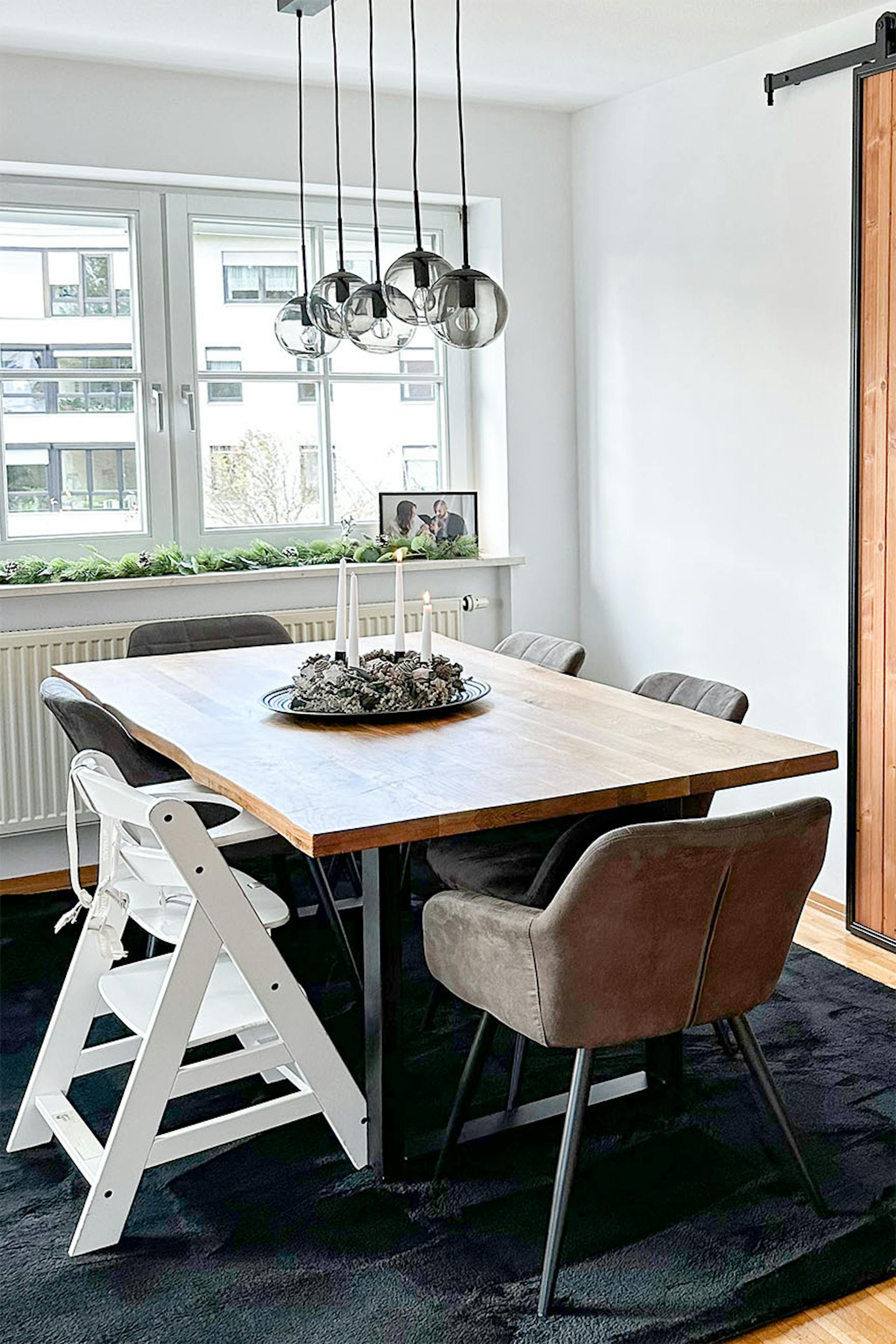 duży stół jadalniany z drewnianym blatem ustawiony obok okna w salonie