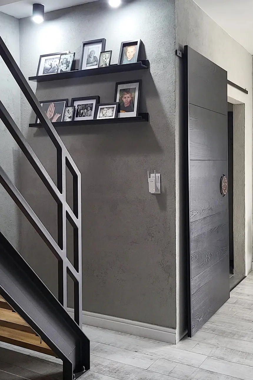 galeria zdjęć w czarnych ramkach na ścianie z szarego betonu