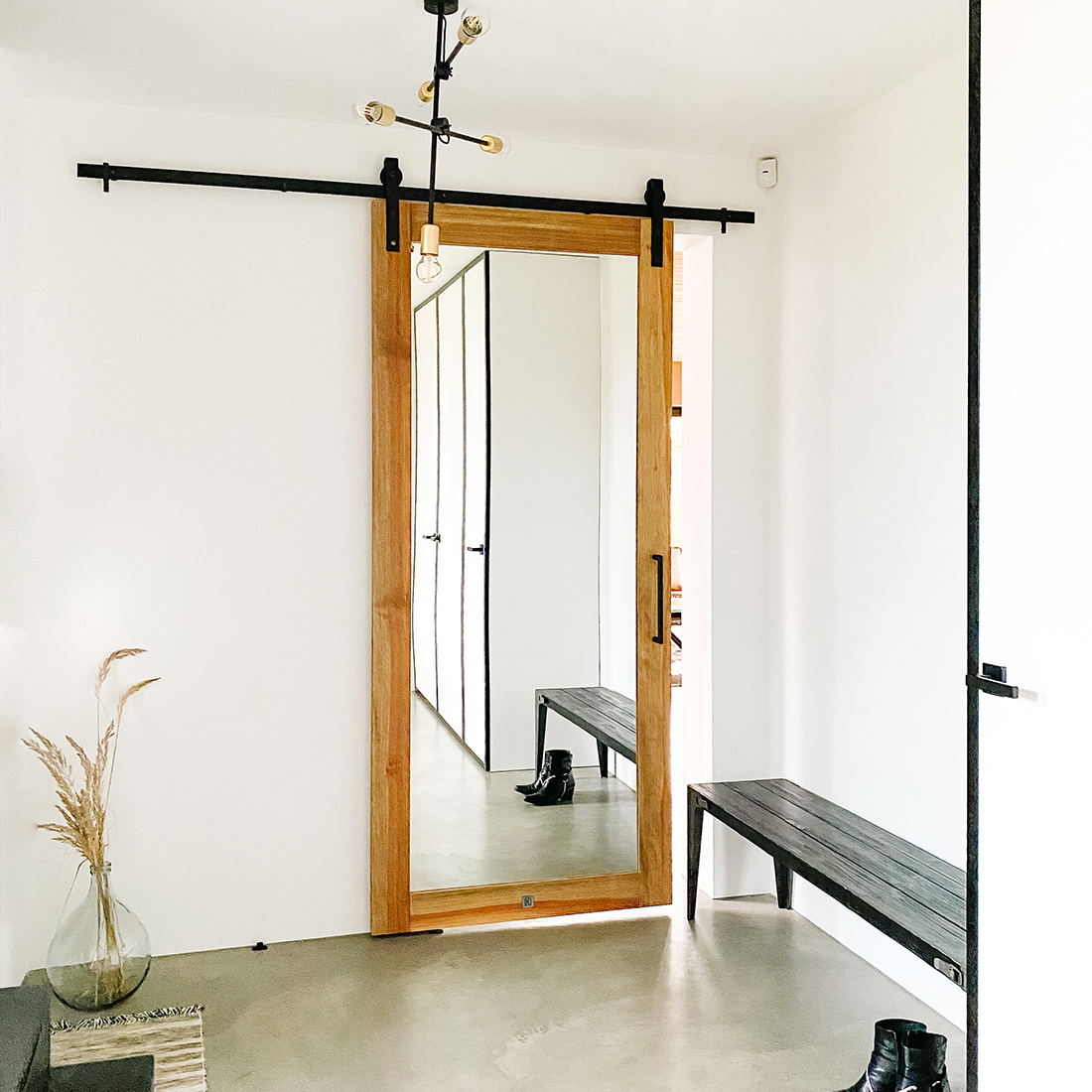 Drzwi przesuwne z lustrem w biało-czarnym przedsionku