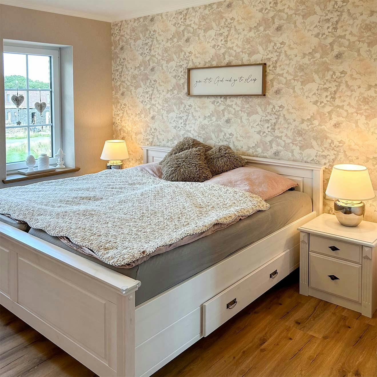 duże łóżko przy ścianie z kwiecistą tapetą w sypialni urządzonej w stylu modern farmhouse