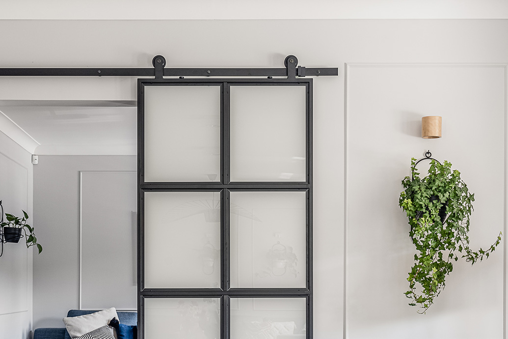 Schiebetüren aus Metall und Glas, milchiges Glas in schwarzem Metallrahmen, industrielle Schiebetüren, Blumenbeet aus Metall an der Wand