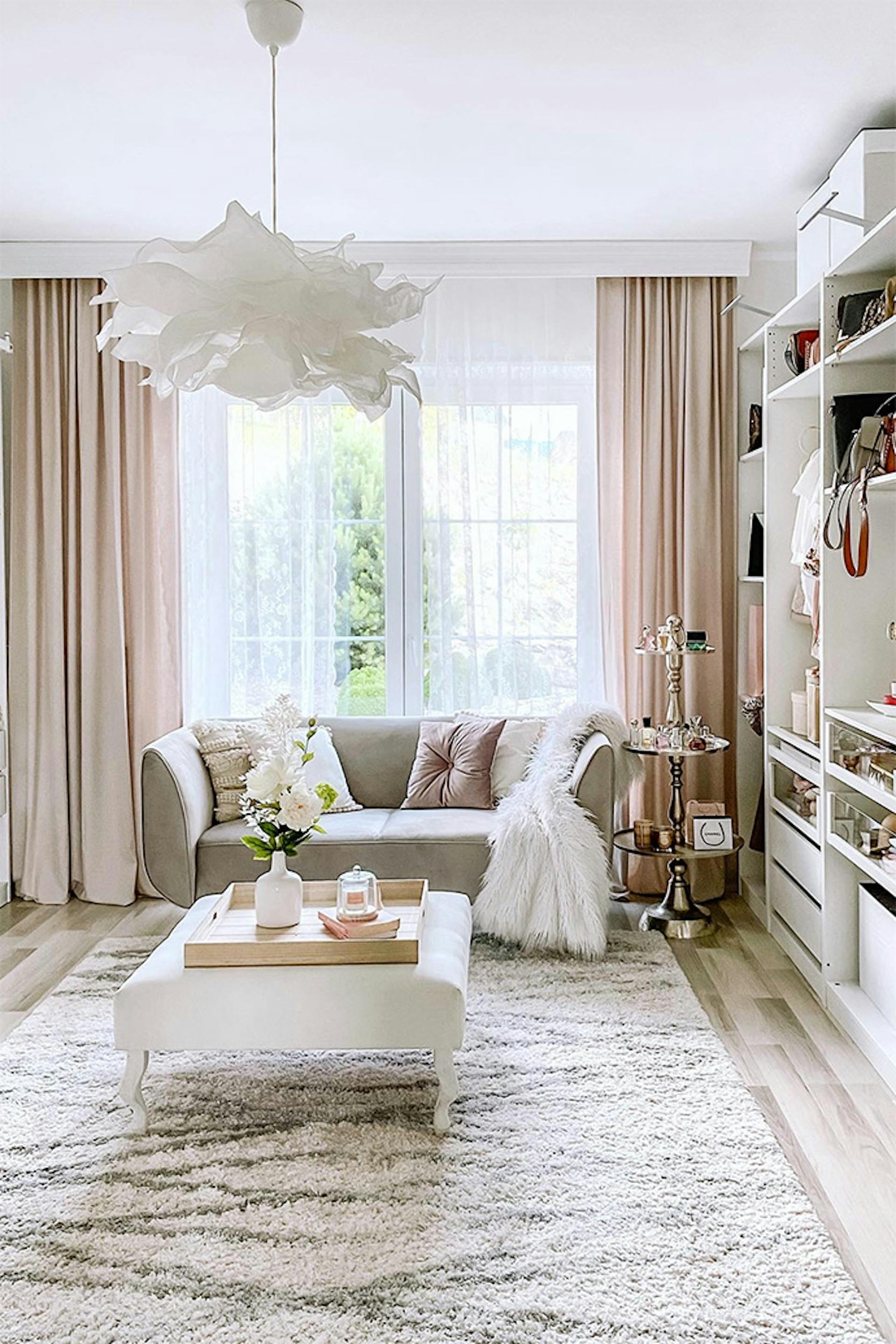 weißer Puff und graues Sofa im Ankleidezimmer, großes helles Ankleidezimmer, weiße Hängelampe, helles begehbarer Kleiderschrank, Pendelleuchte Papier Lampenschirm