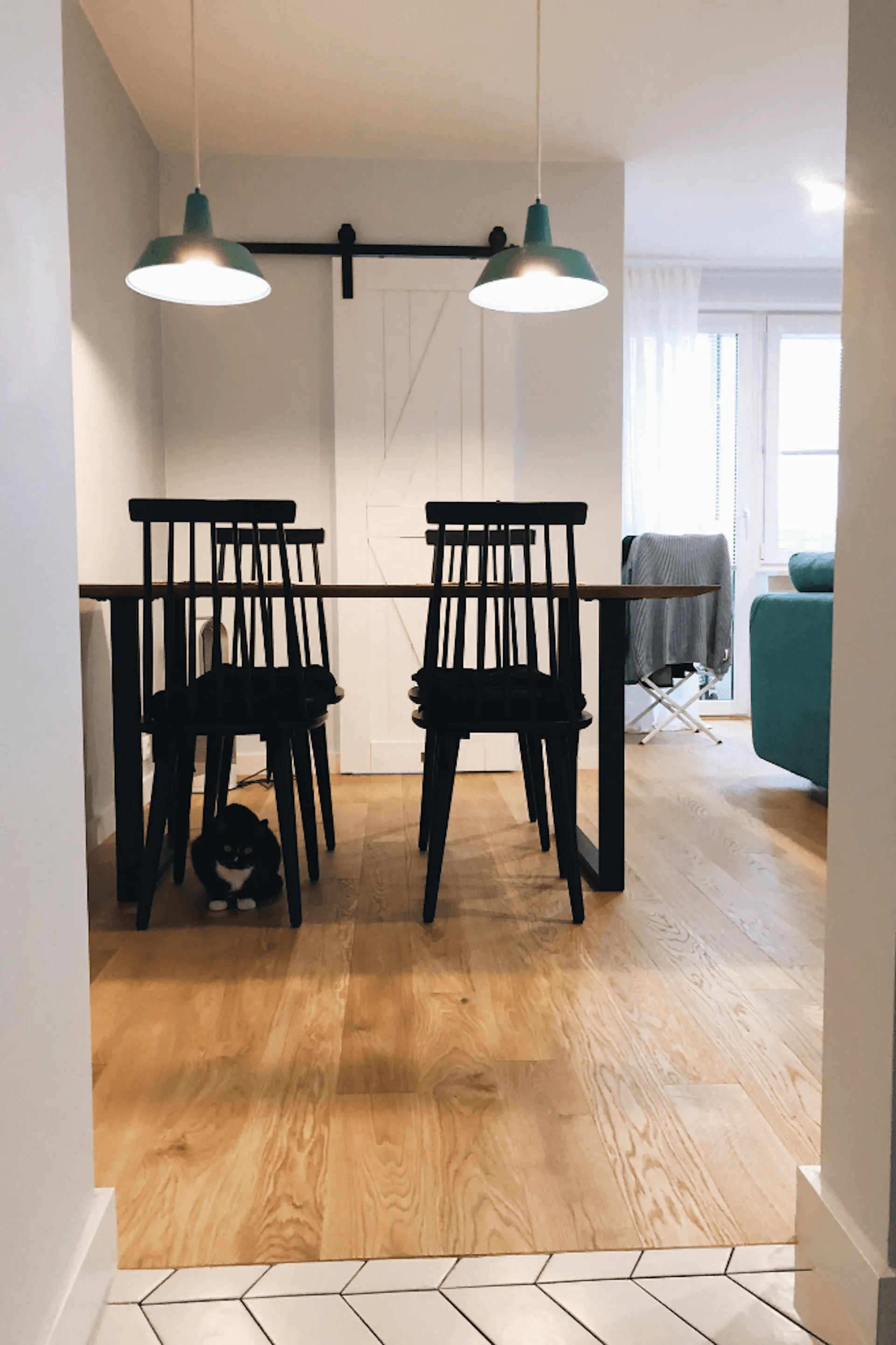 flaschengrün im Innenraum, weiße Schiebetür, industriellem Innenraum, Metallzubehör im Innenraum, Holzschiebetür, "barn door"-Stil Schiebetüren, grüne Hängelampe, schwarze Stühle