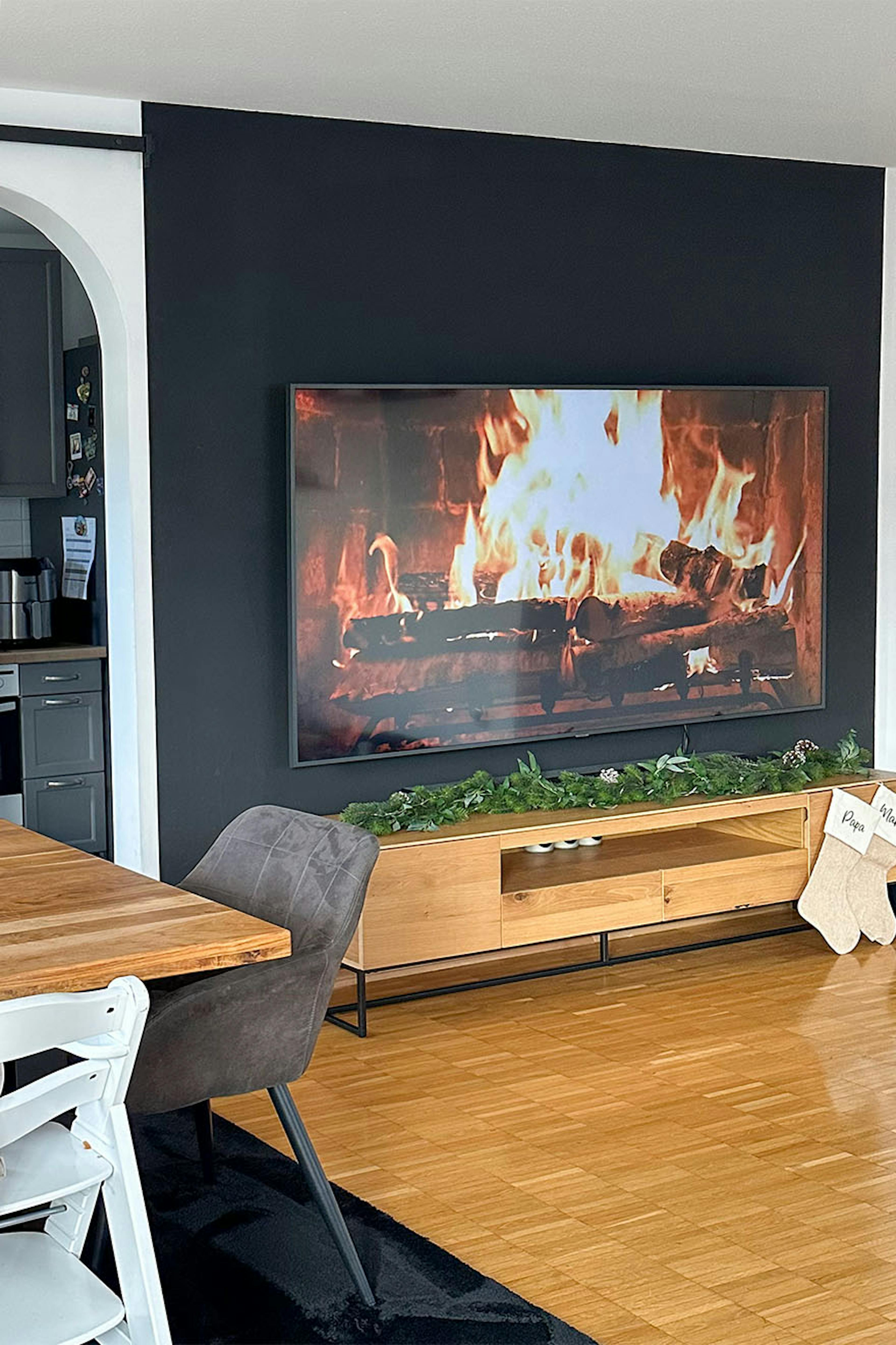 Schwarze Wand in Fernsehecke mit niedrigem Holzschrank