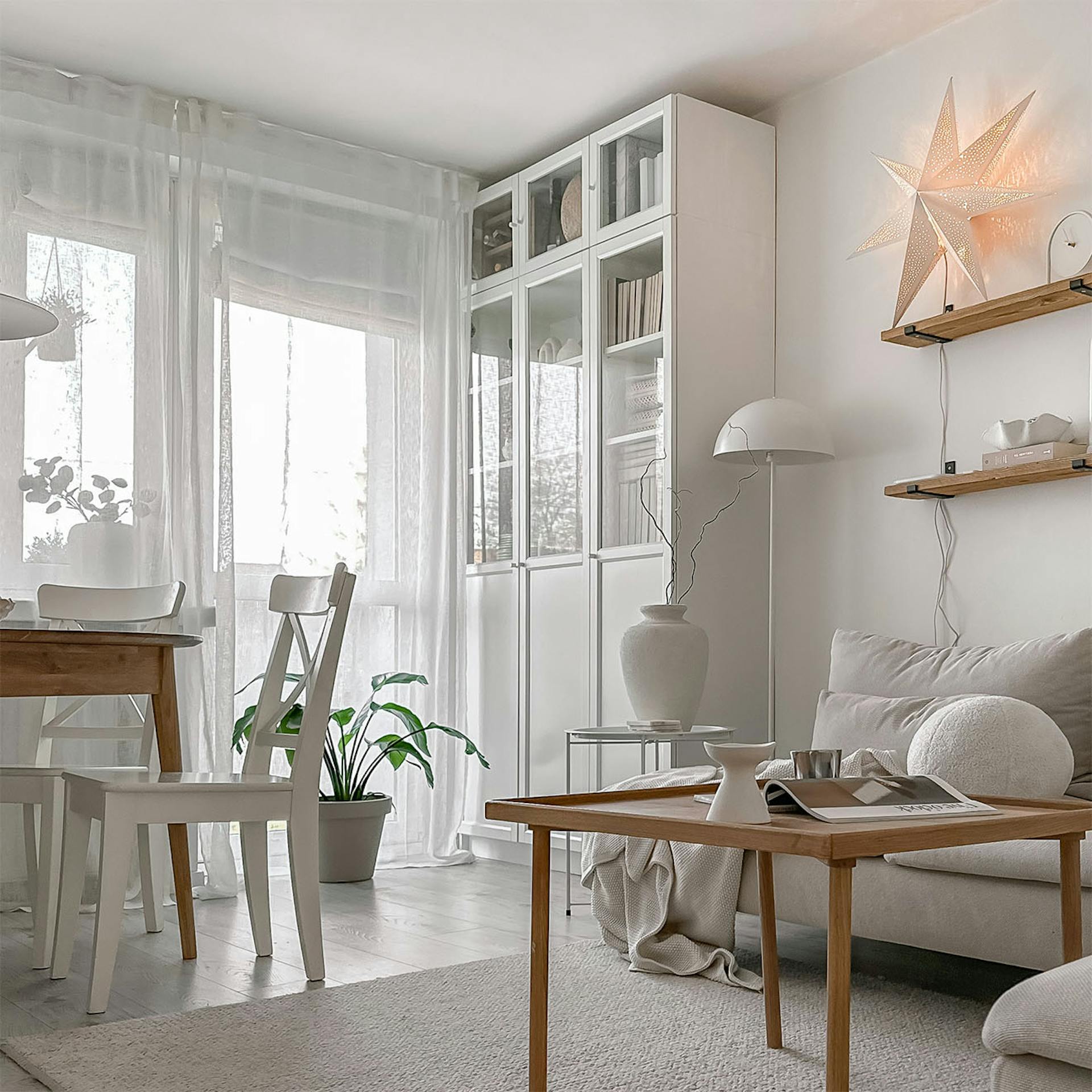 drewniany stolik kawowy, biała szafa z przeszkleniem w salonie w bloku