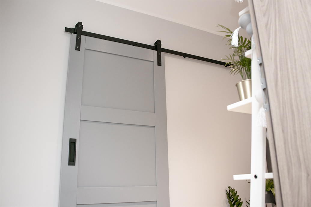 szare drzwi przesuwne na białej ścianie korytarza