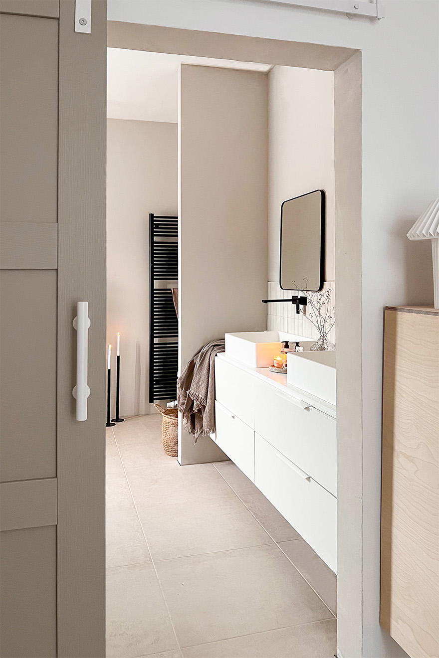 weißer Waschtisch mit zwei Waschbecken in einem grauen und beigen Badezimmer