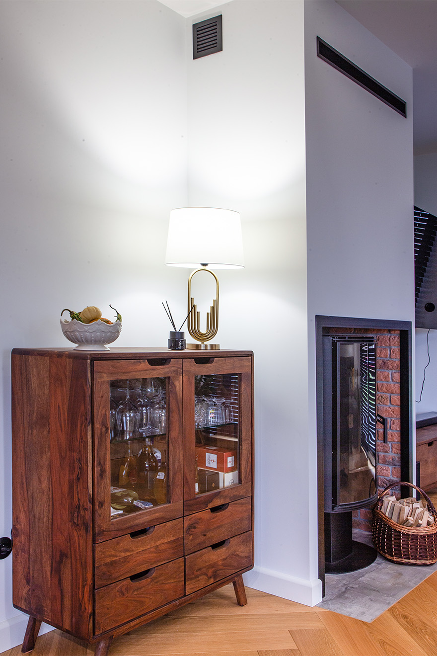 Holzvitrine mit Schubladen und Glasfronten vor einer weißen Wand