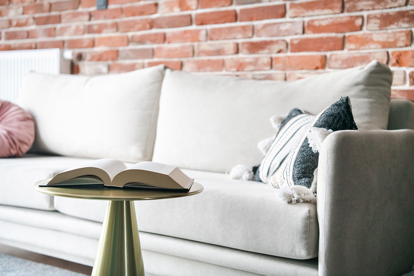 helles Sofa und rote Ziegelwand im Wohnzimmer