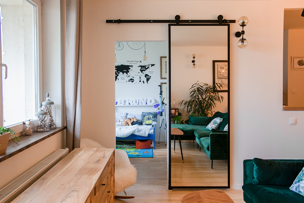 ein Spiegel in einem Metallrahmen in einer eklektischen Wohnzimmereinrichtung