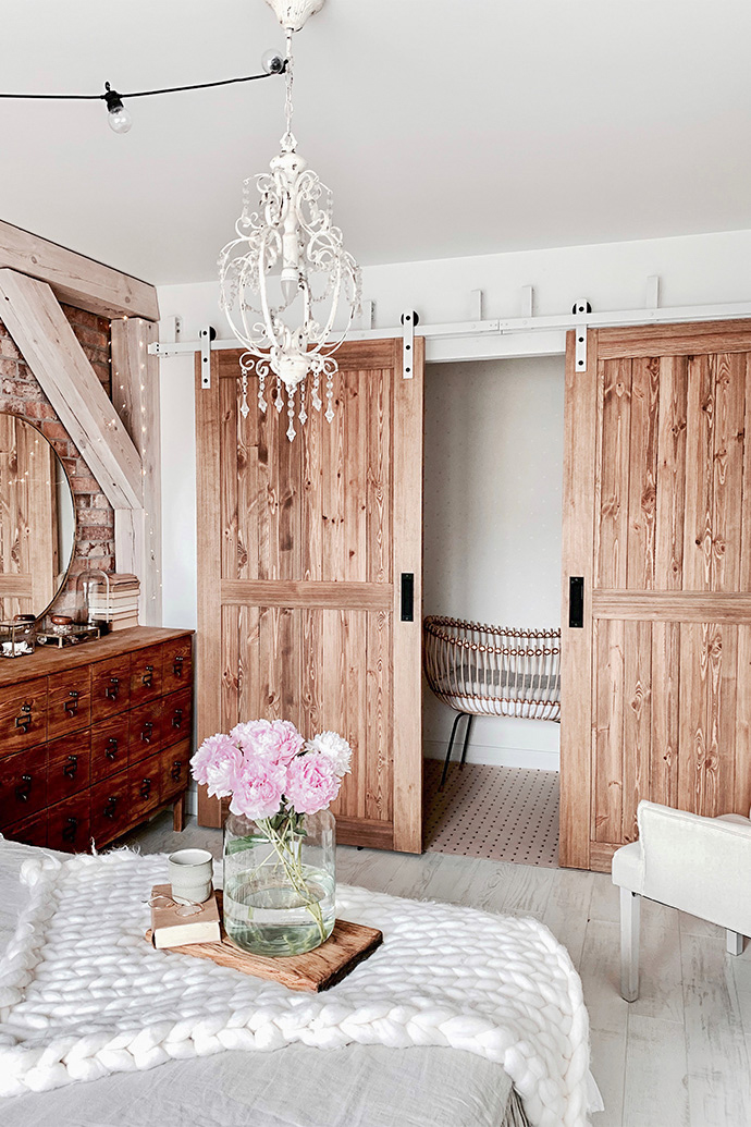 rustic bedroom, wooden sliding door, sliding door, rustic style interior, modern rustic style, barn sliding doors, white sliding system, bypass sliding doors, bypass wall bracket for sliding doors, white rustic chandeliers, brick bedroom wall