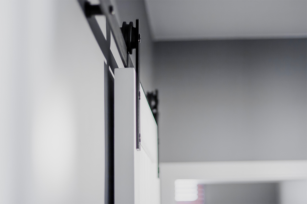 Schiebesystem, weiße Schiebetür, graue Wände in der Halle