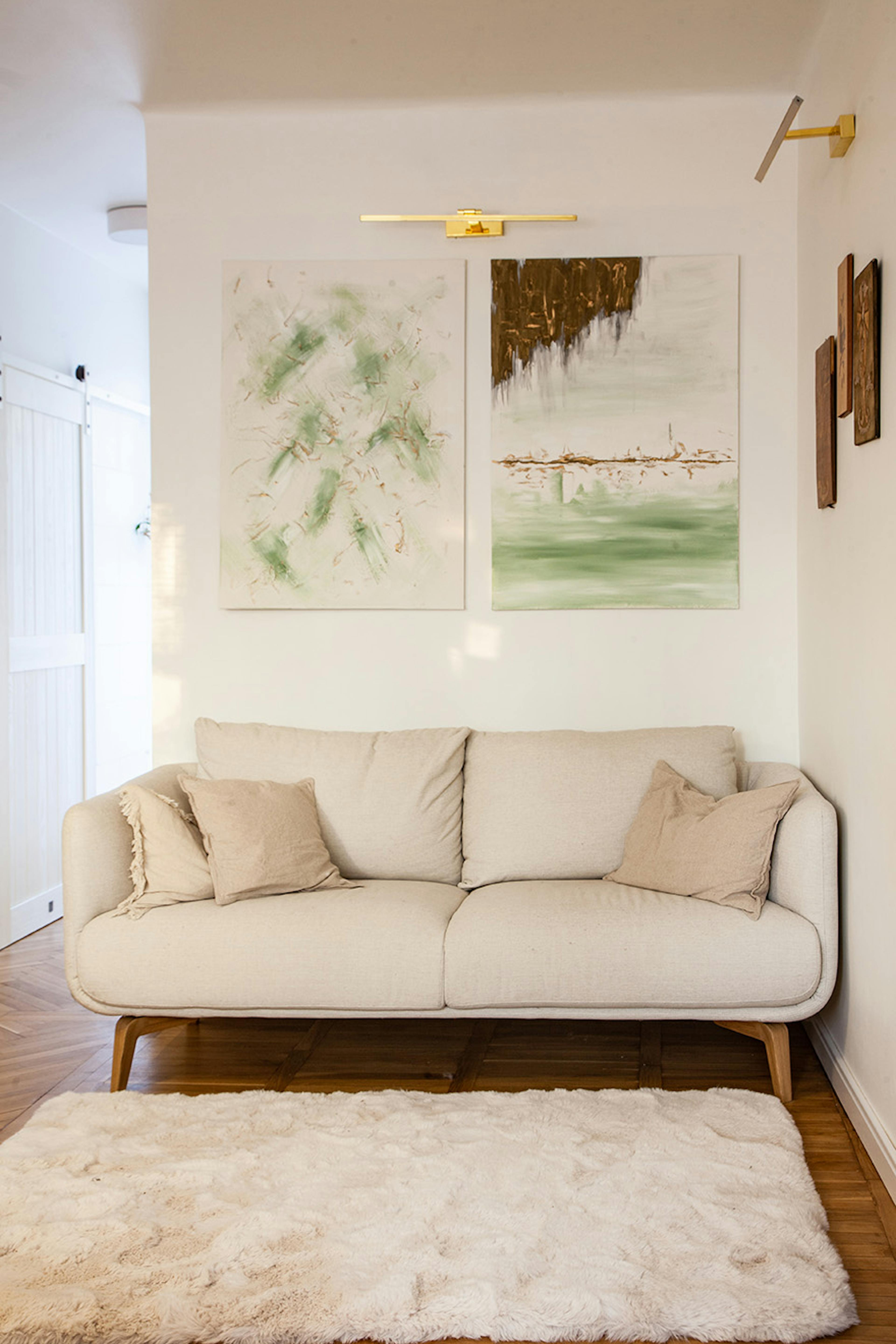 Gemälde, die über einem hellen Sofa im Wohnzimmer hängen
