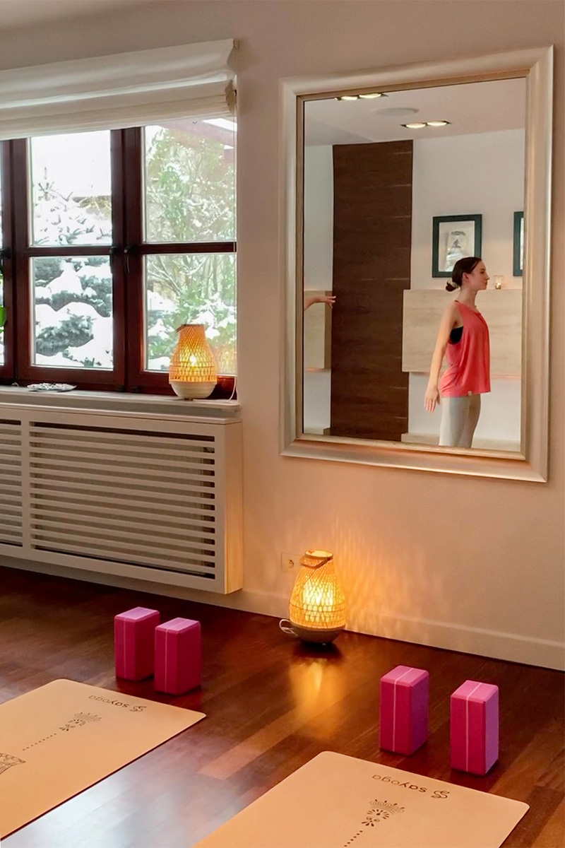 duże lustro na ścianie w małym studio jogi