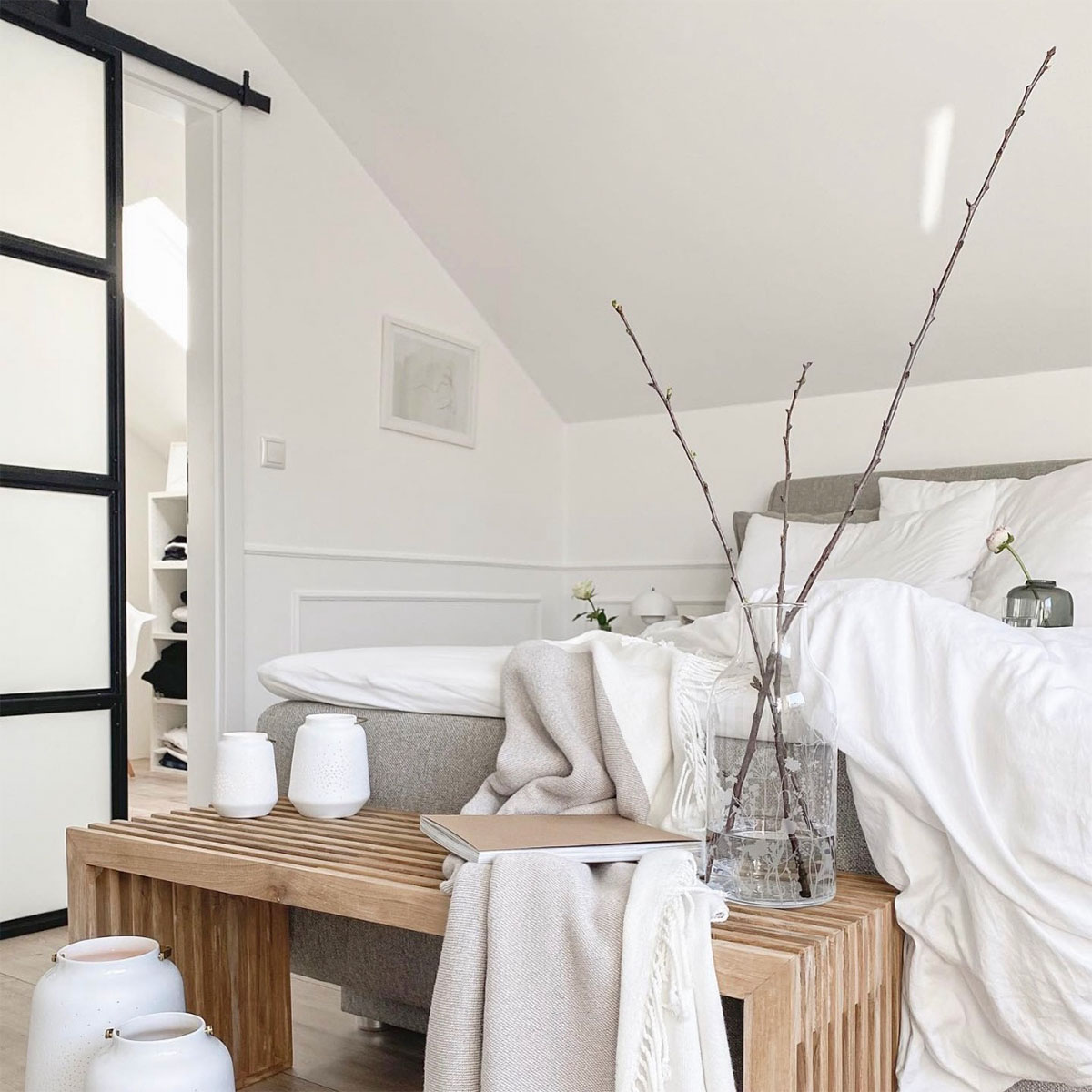 biel i drewno w aranżacji sypialni na poddaszu w stylu nordyckim